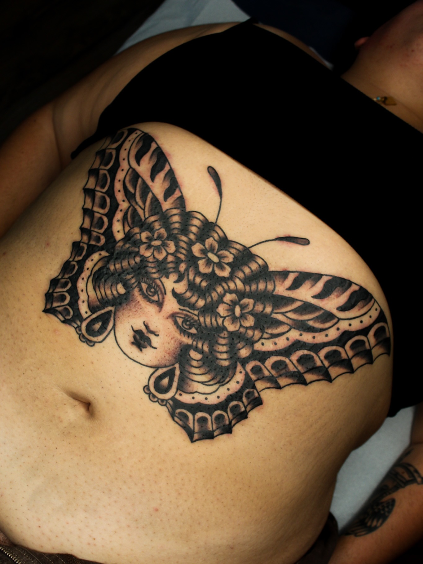 Woman with butterfly wings American traditional tattoo on the torso by Kehrmie Tattoos, Berkeley, California