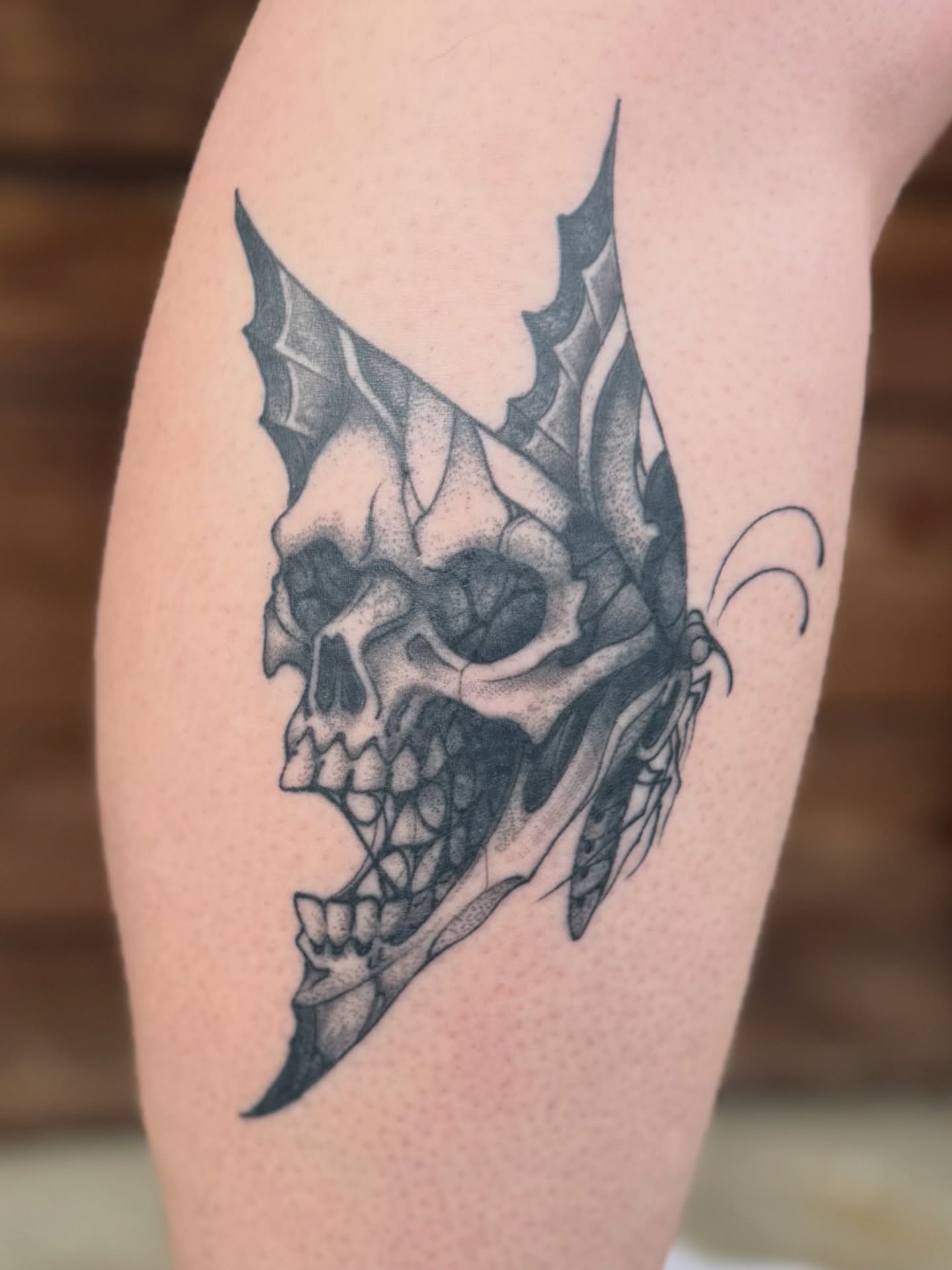 Skull with butterfly wings dotwork tattoo on the forearm by Scott Kulikowski