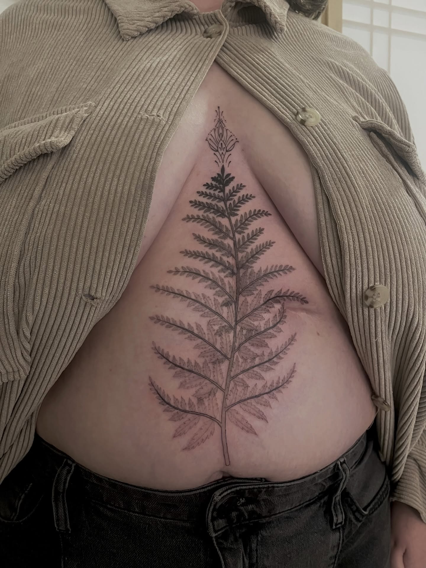 Fern leaf black and grey tattoo on the ribs by Lo Gwynn