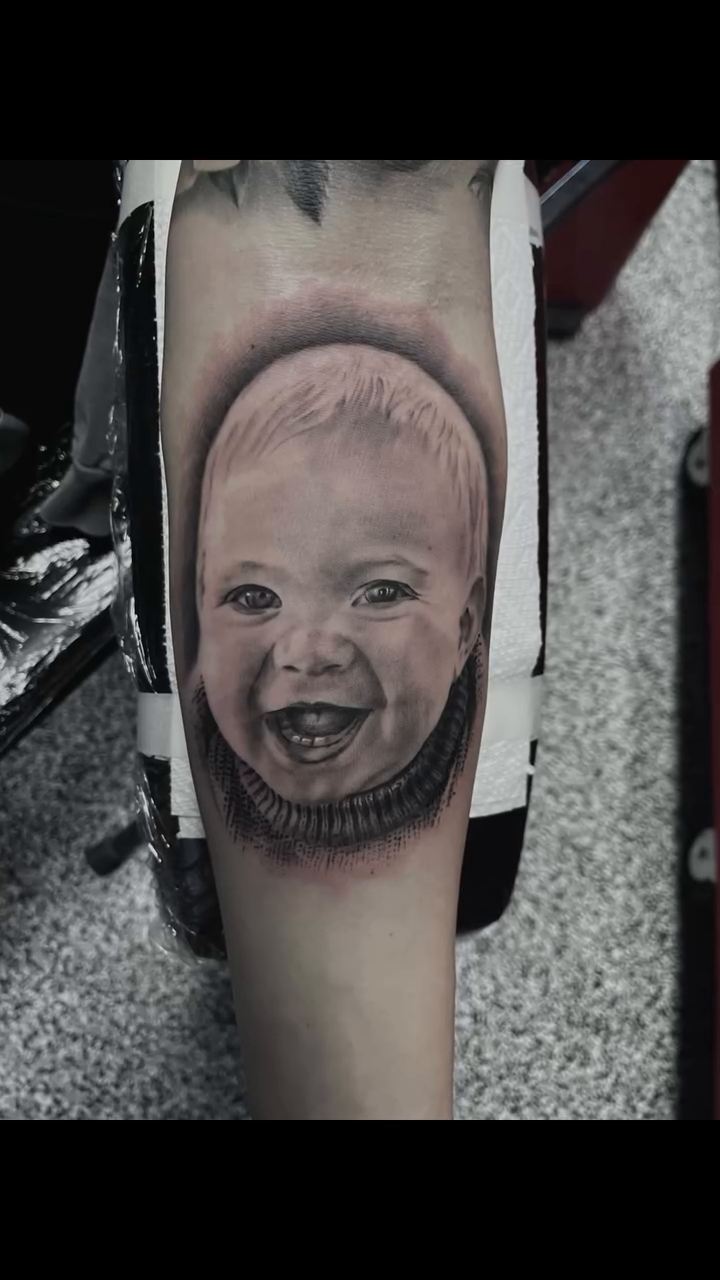 Baby portrait realism tattoo on the forearm by Jonathan Red