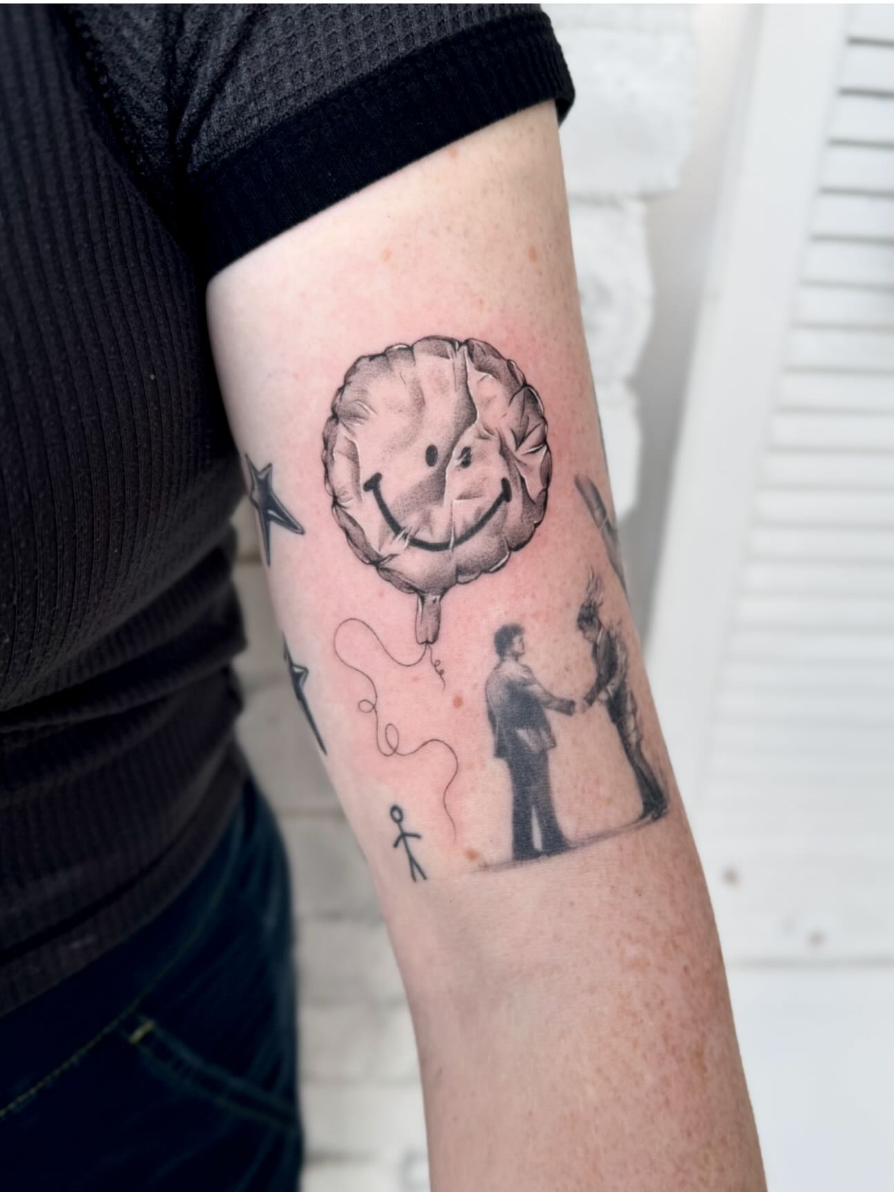 Smiley balloon black and grey tattoo on the forearm by Lily Cuoio~ Seattle