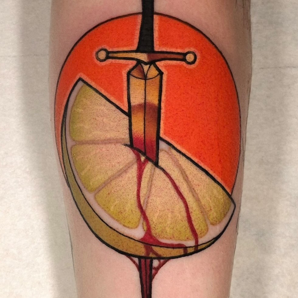 Sword through lemon American traditional tattoo on the forearm by Nathan Thomas