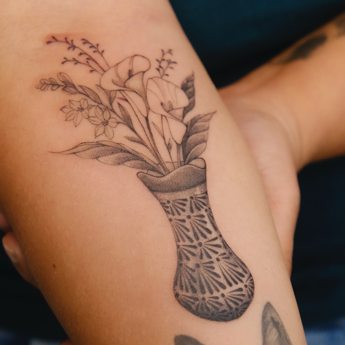 Flower bouquet in vase black and grey tattoo on the upper arm by Ka hiu chiu