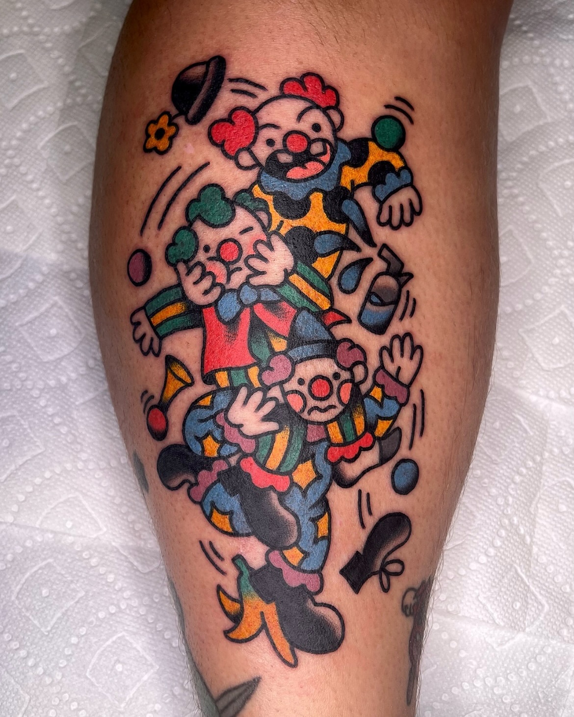 Clowns American traditional tattoo on the thigh by Robyn Fricke