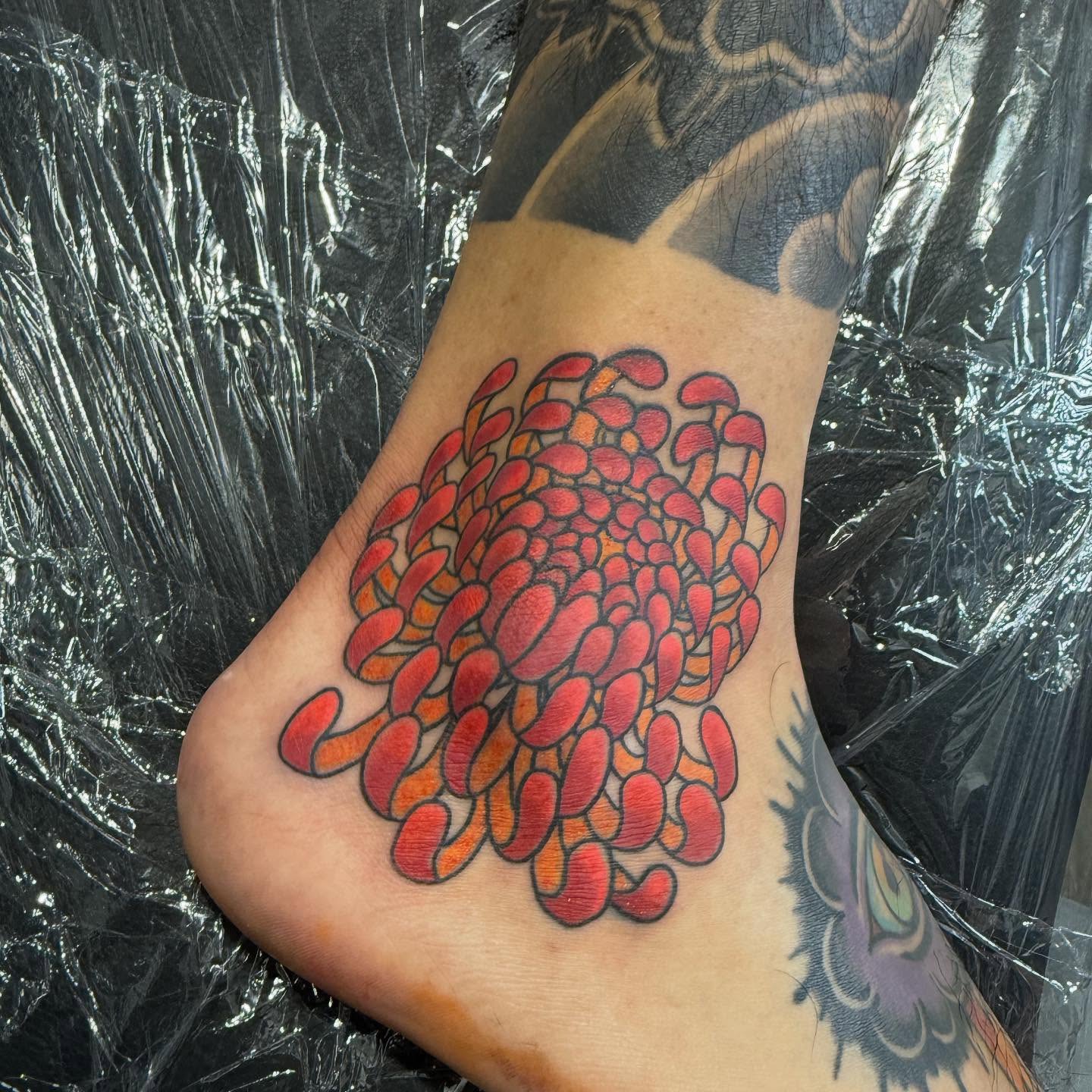 Chrysanthemum dotwork tattoo on the foot by Randall Croley El