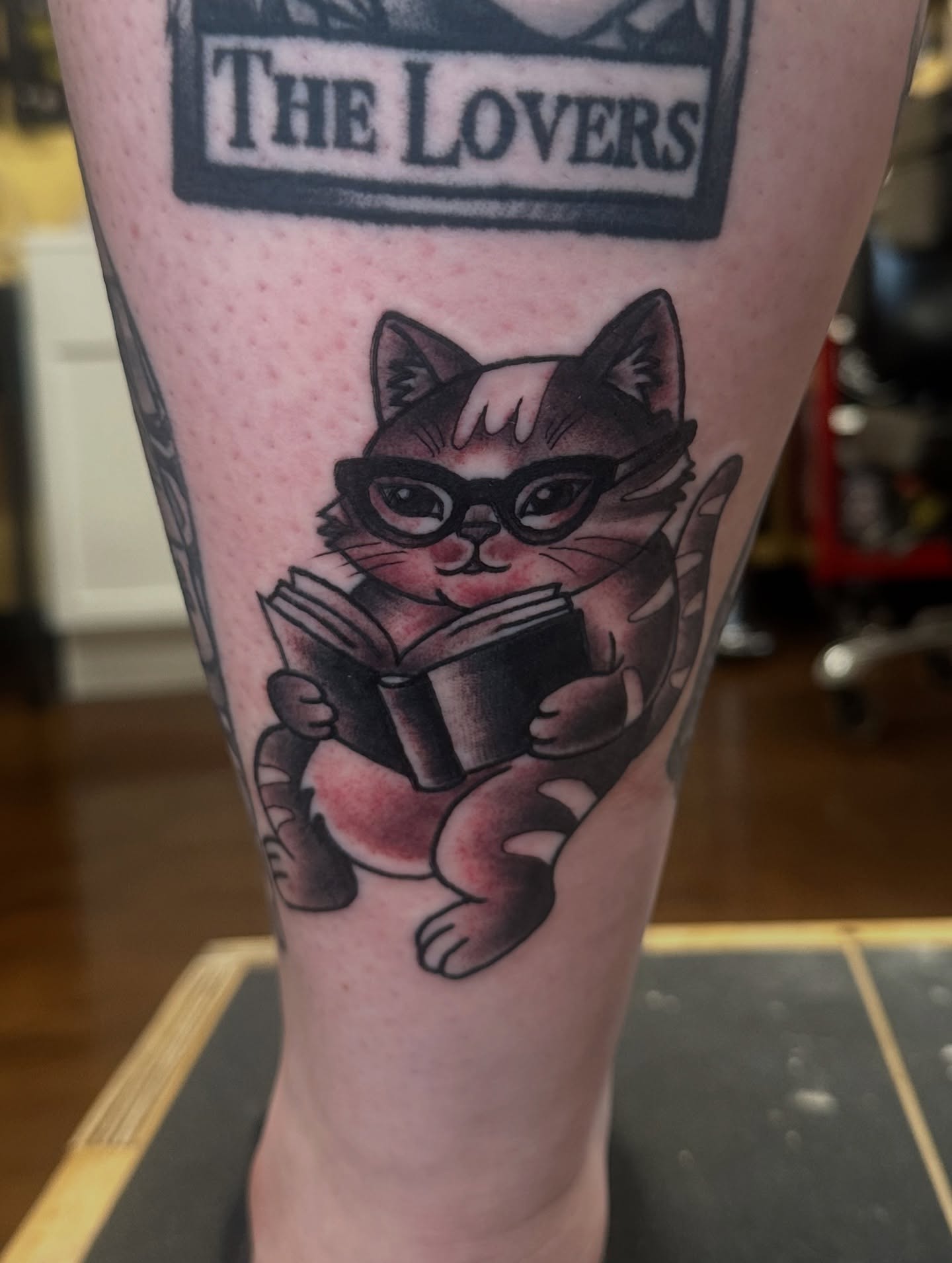Cat reading book realism tattoo on the forearm by Nick Bones, Las Vegas, Nevada