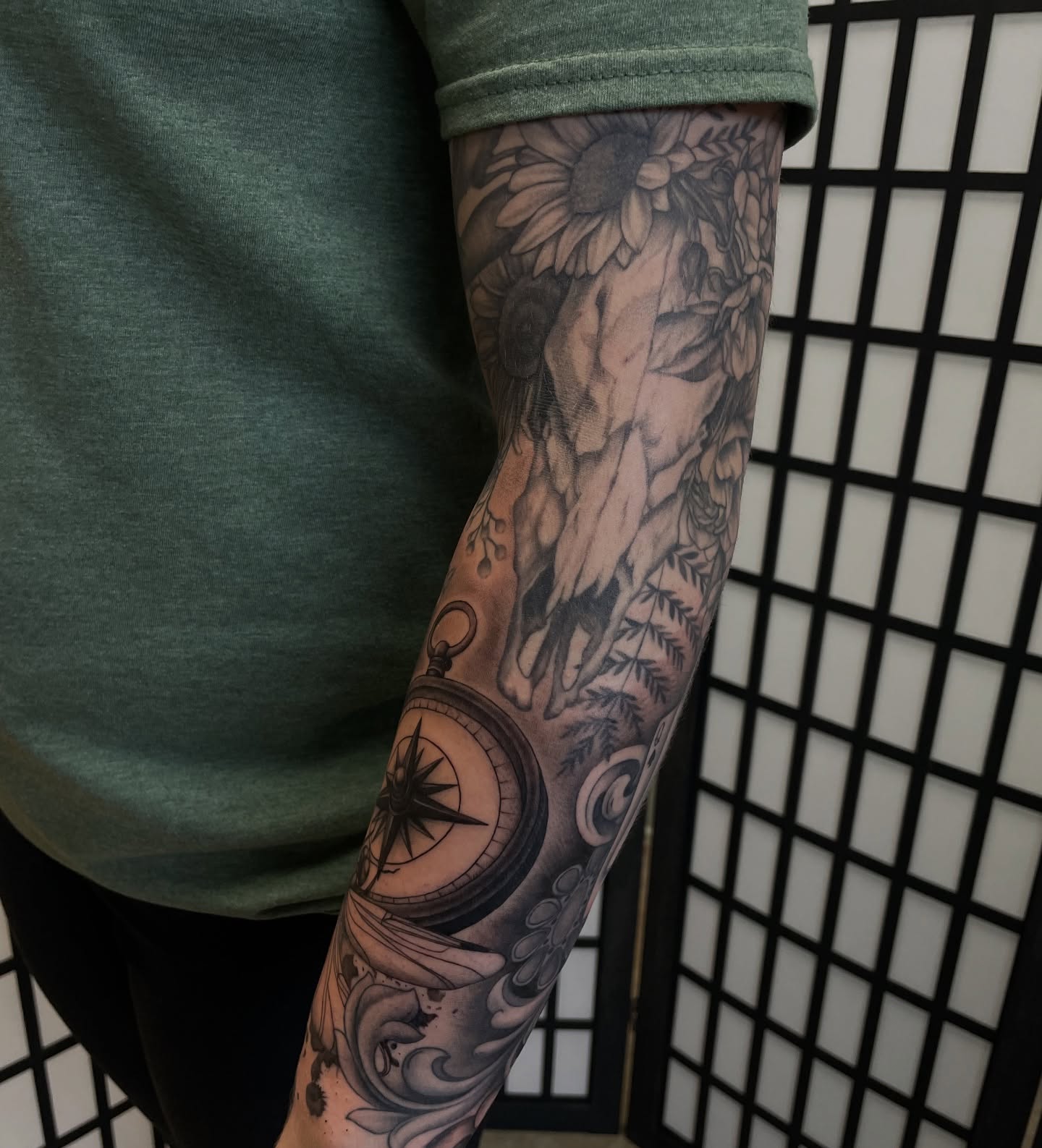 Sunflower and compass black and grey tattoo on the forearm by kaylee