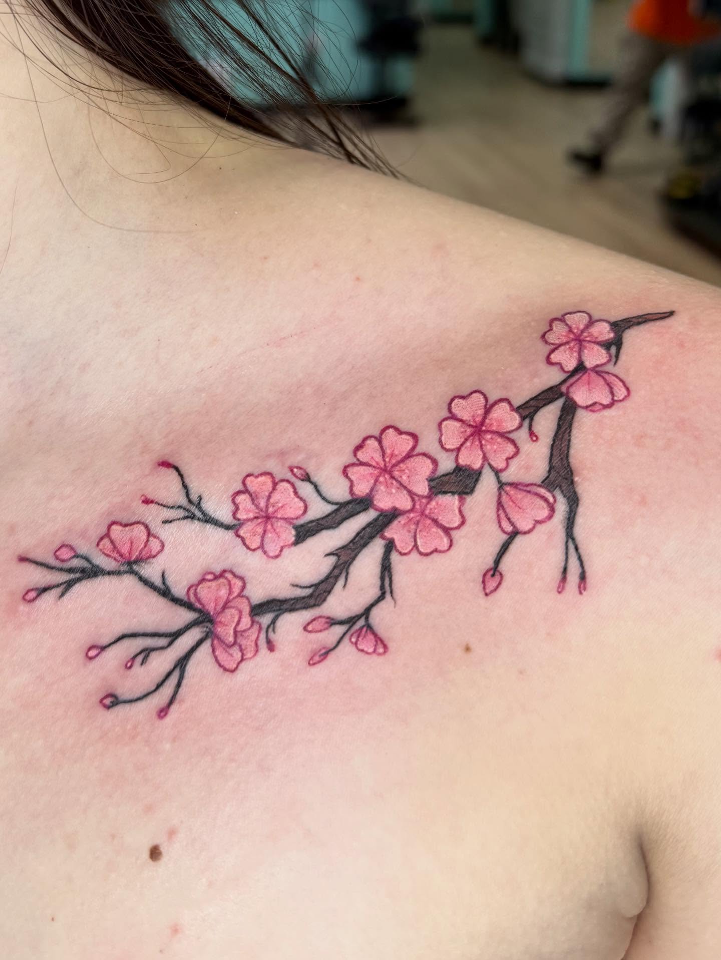 Cherry blossom branch watercolor tattoo on the shoulder by Bry