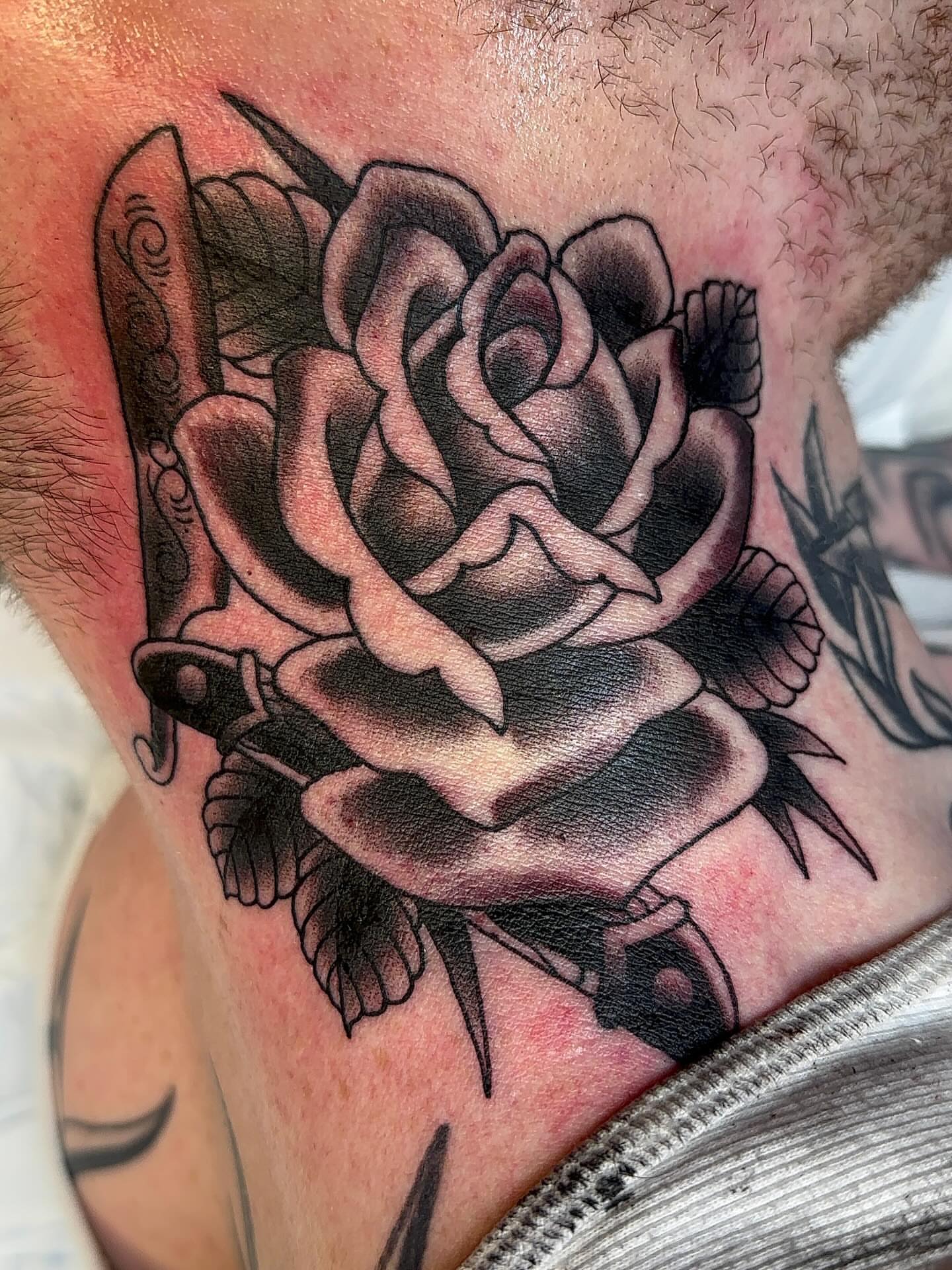 Rose and knife American traditional tattoo on the chest by Cody Hanson