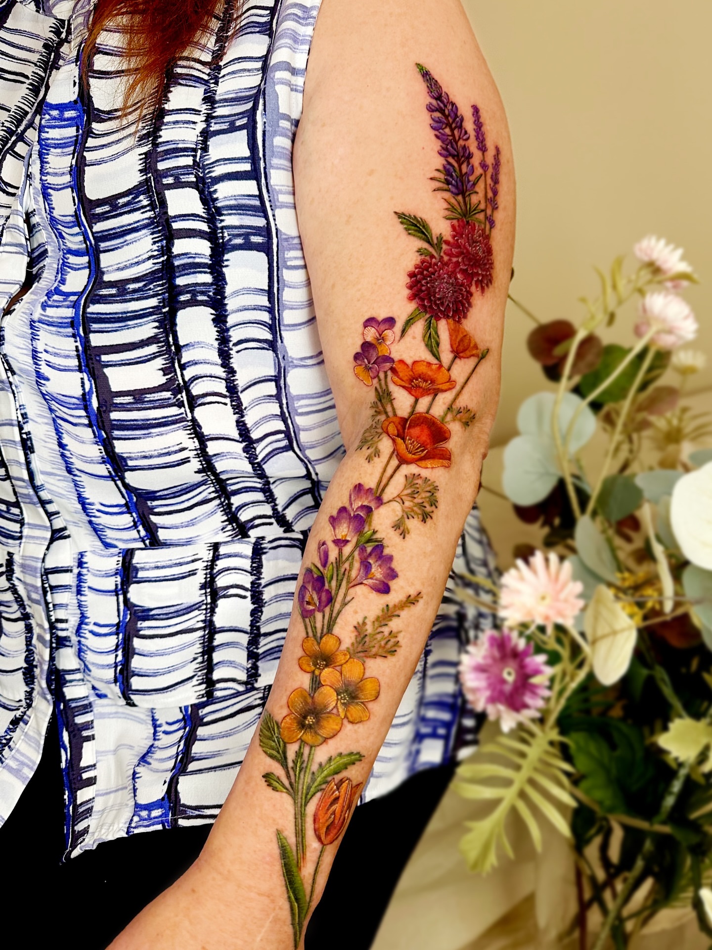 Floral bouquet realism tattoo on the forearm by Claire