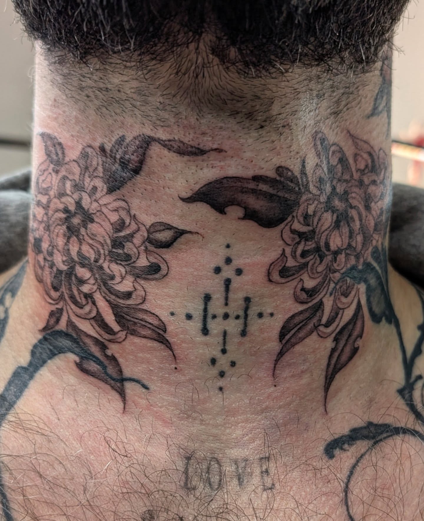 Chrysanthemums and cross dotwork tattoo on the neck by Katherine