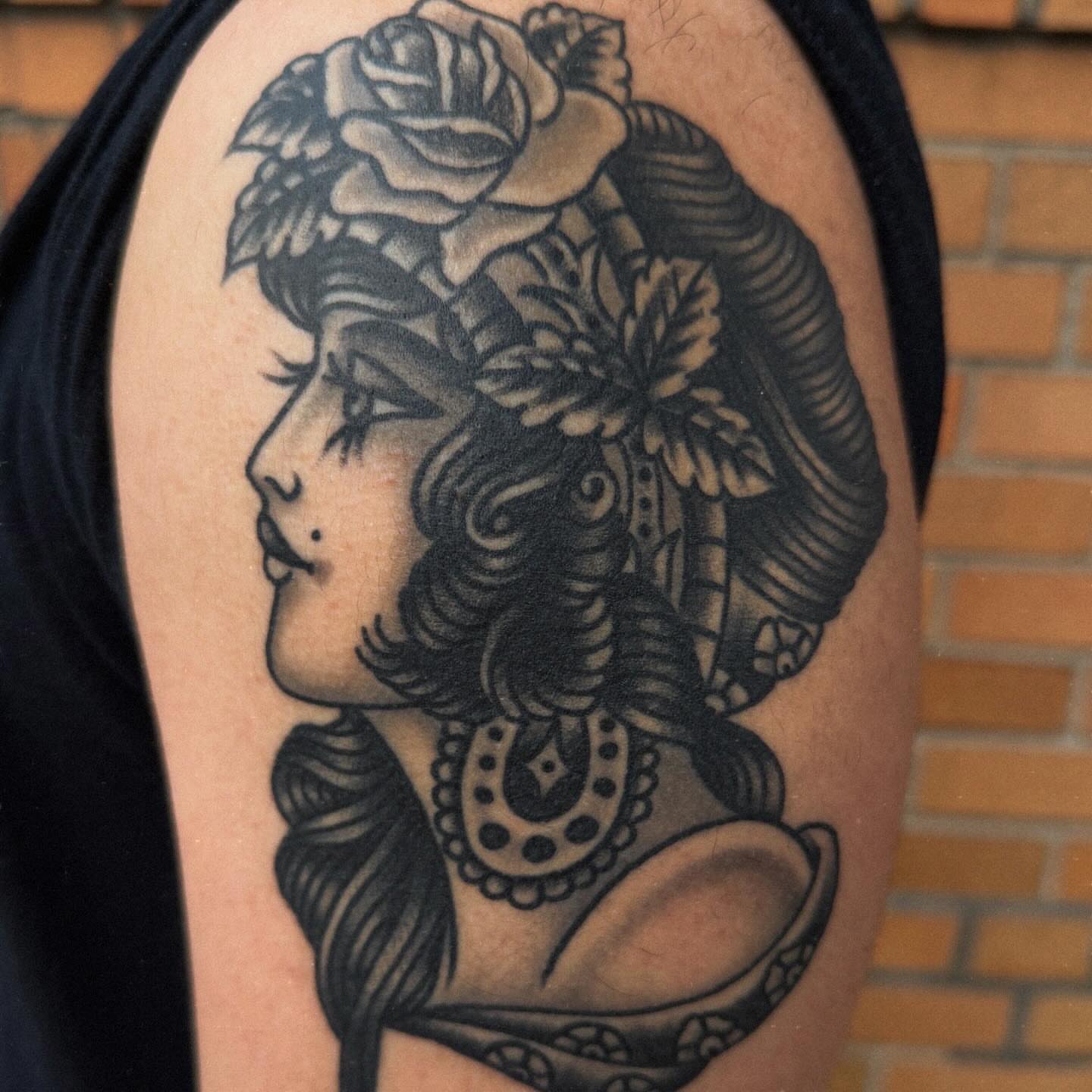 Woman with flowers American traditional tattoo on the shoulder by Tony Kaplan
