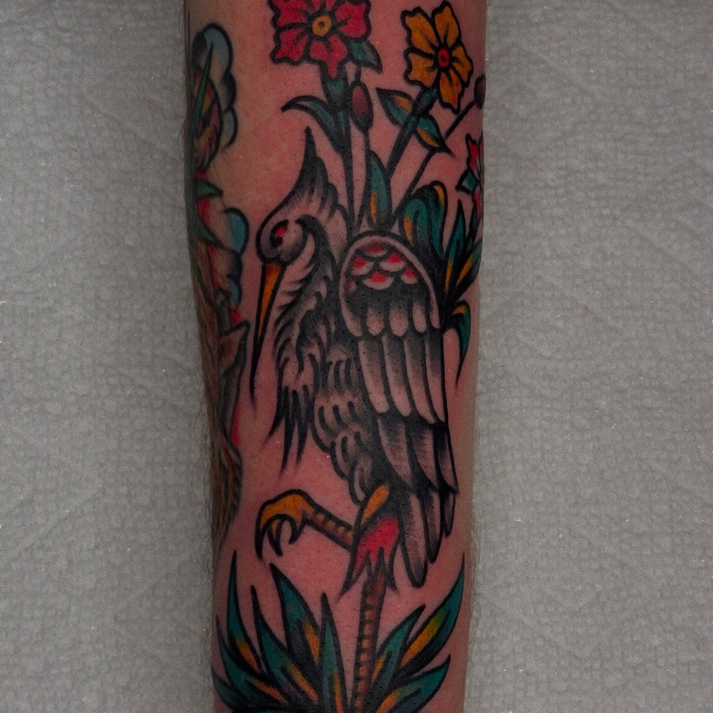 Heron and flowers American traditional tattoo on the forearm by Tony Kaplan