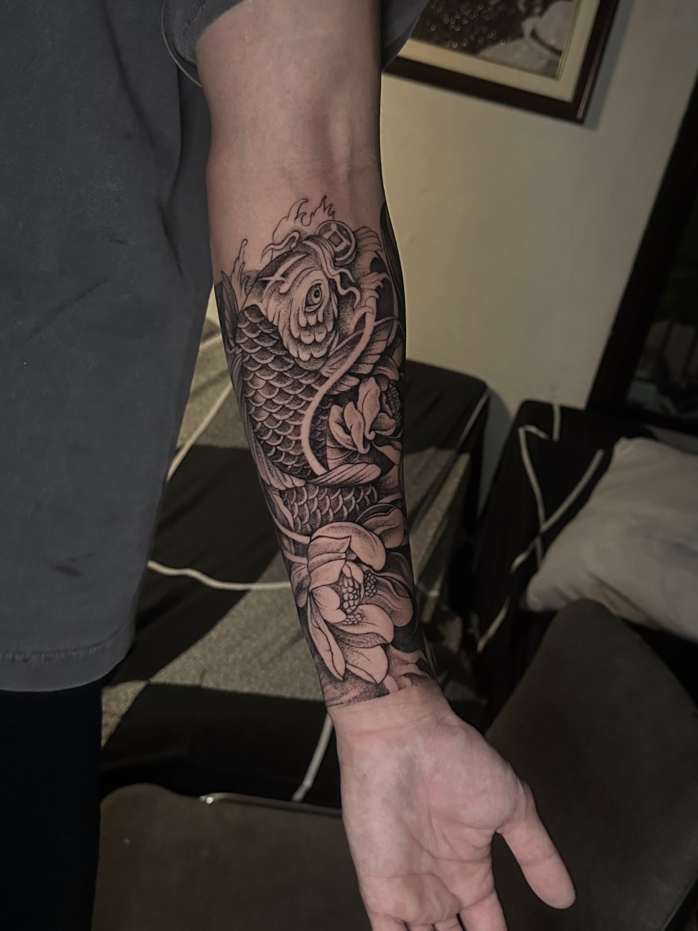 Koi fish and lotus flower realism tattoo on the forearm by Arhem Quiambao