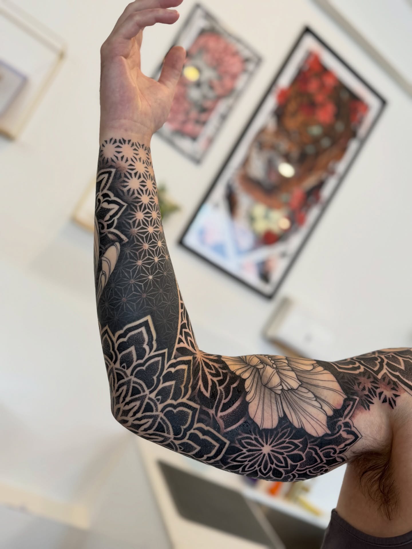 Geometric floral pattern geometric tattoo on the upper arm by Laure Conzales