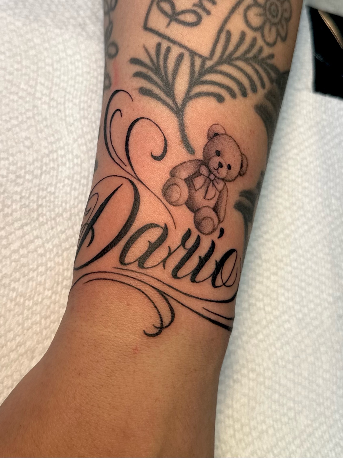 Teddy bear black and grey tattoo on the forearm by Ghost
