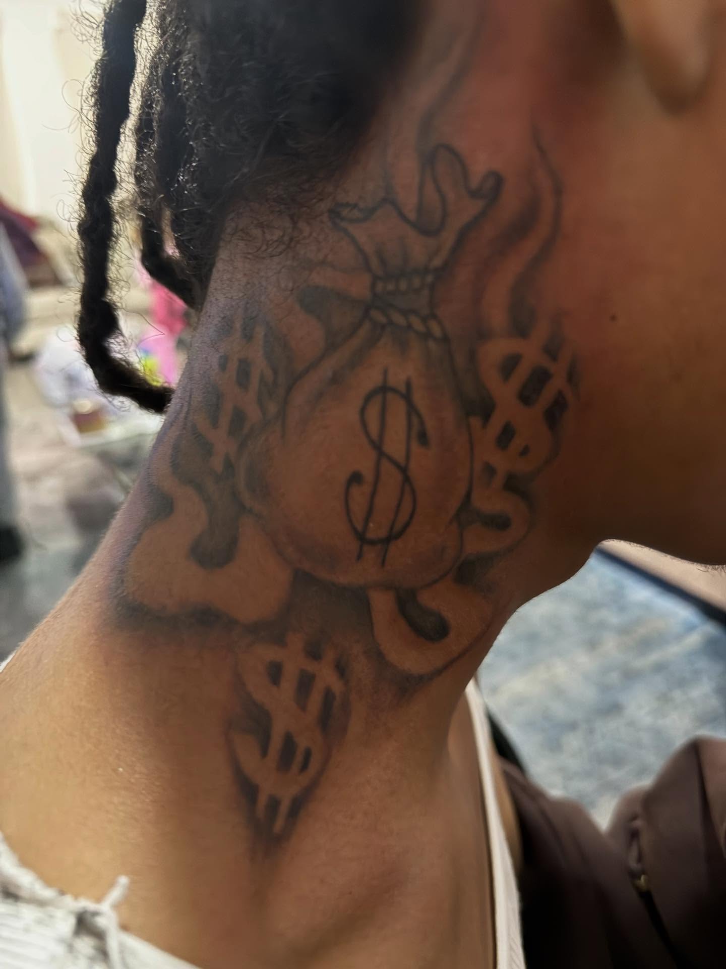 Money bag black and grey tattoo on the neck by Aja Marie