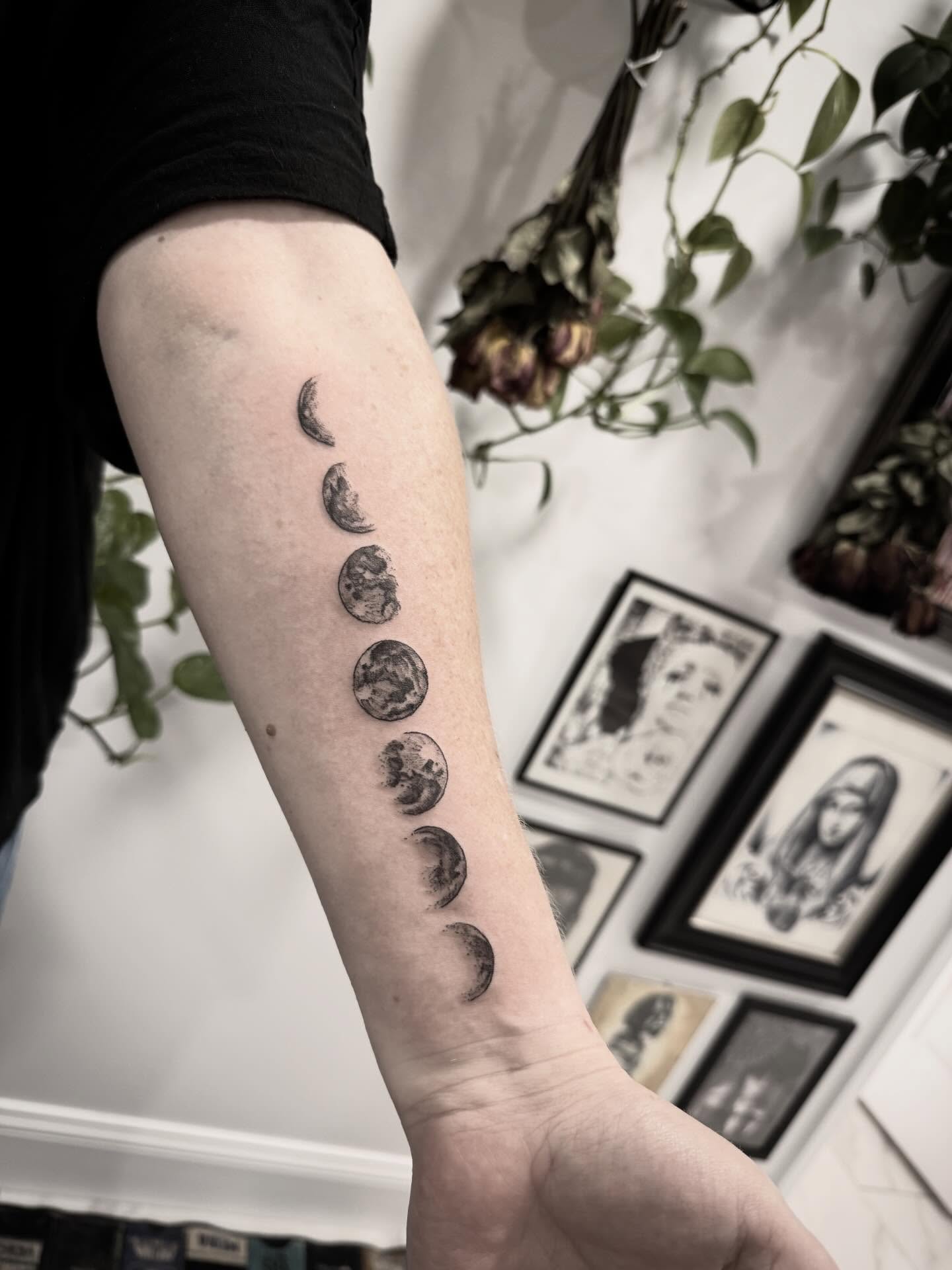 Moon phases black and grey tattoo on the forearm by Shannon Misitano