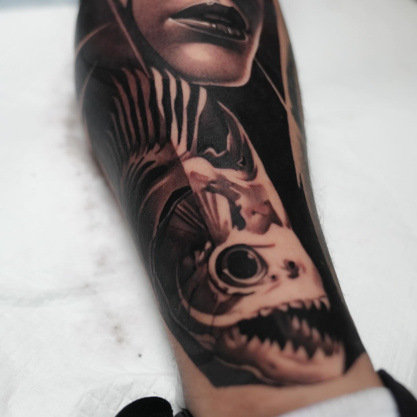 Woman's face with fish realism tattoo on the forearm by Fábio Guerreiro