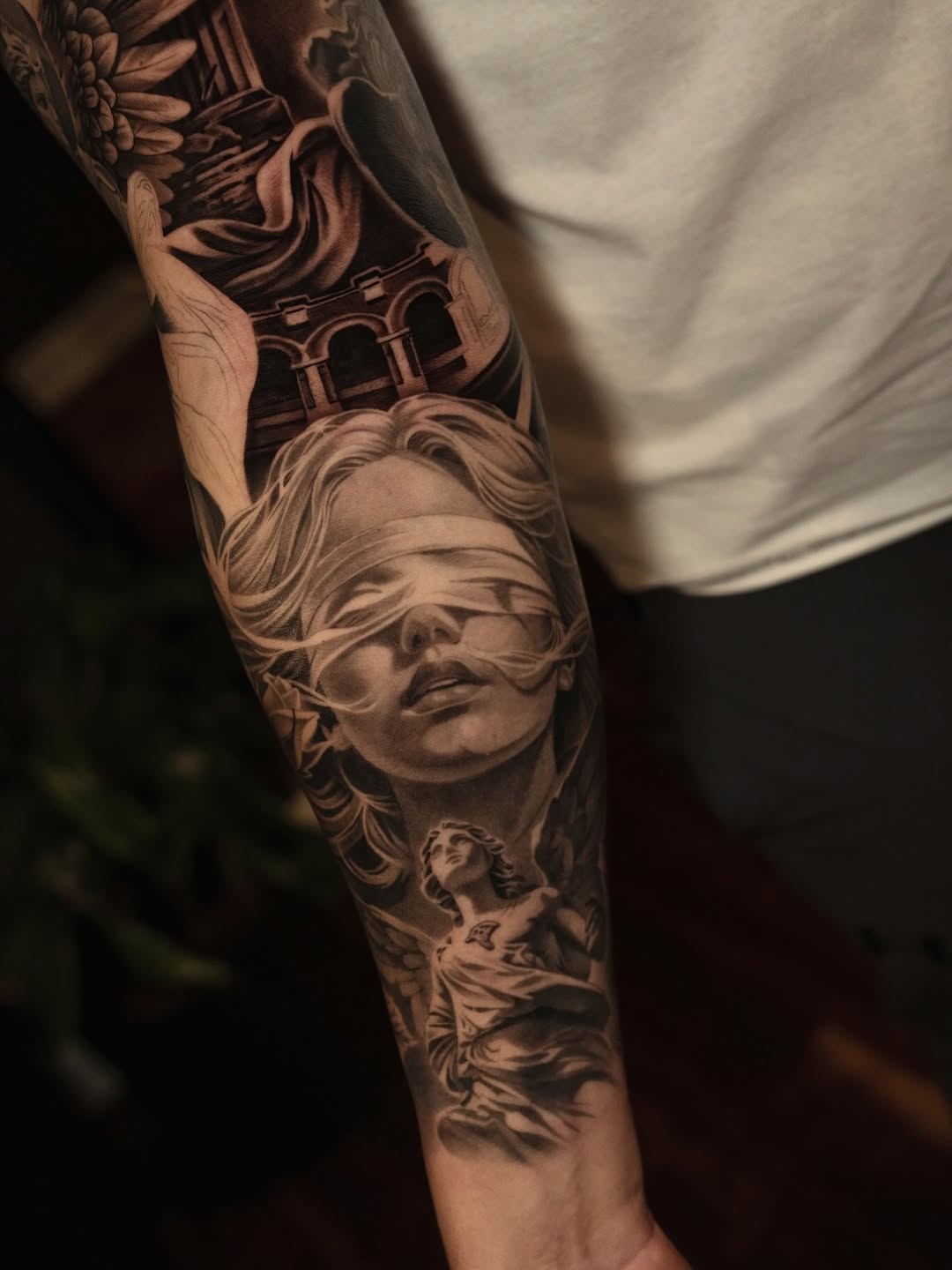 Blindfolded woman and angel realism tattoo on the forearm by @kotytattoos