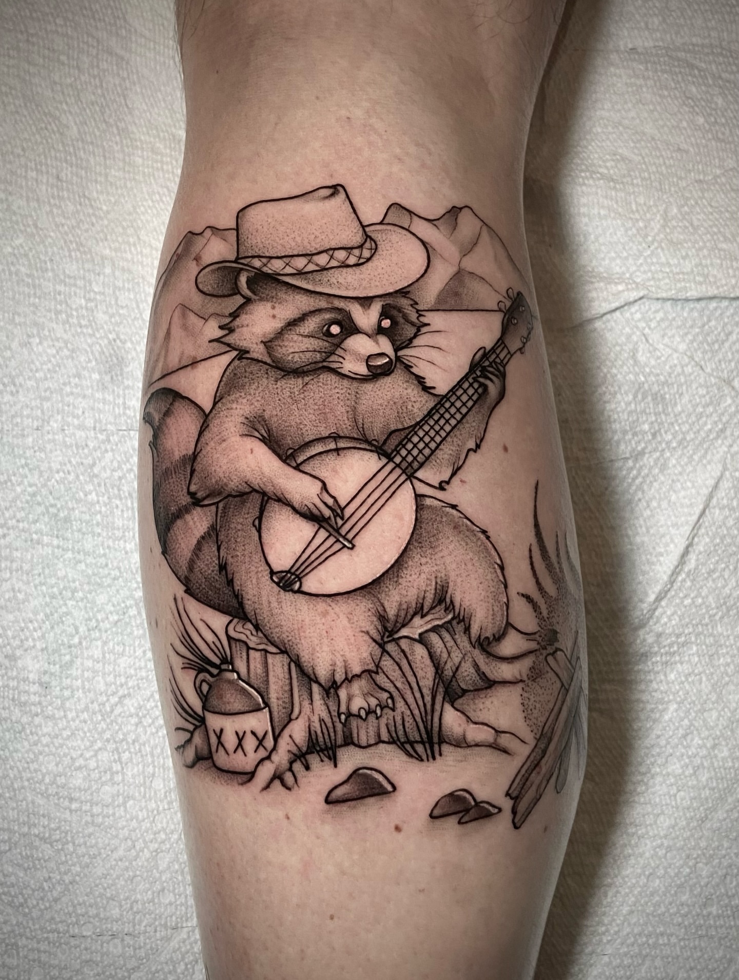 Raccoon playing banjo dotwork tattoo on the forearm by Zac Byrd