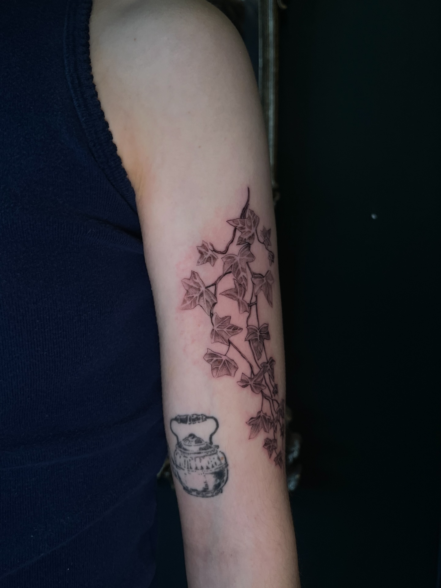 Ivy and teapot black and grey tattoo on the forearm by Samantha