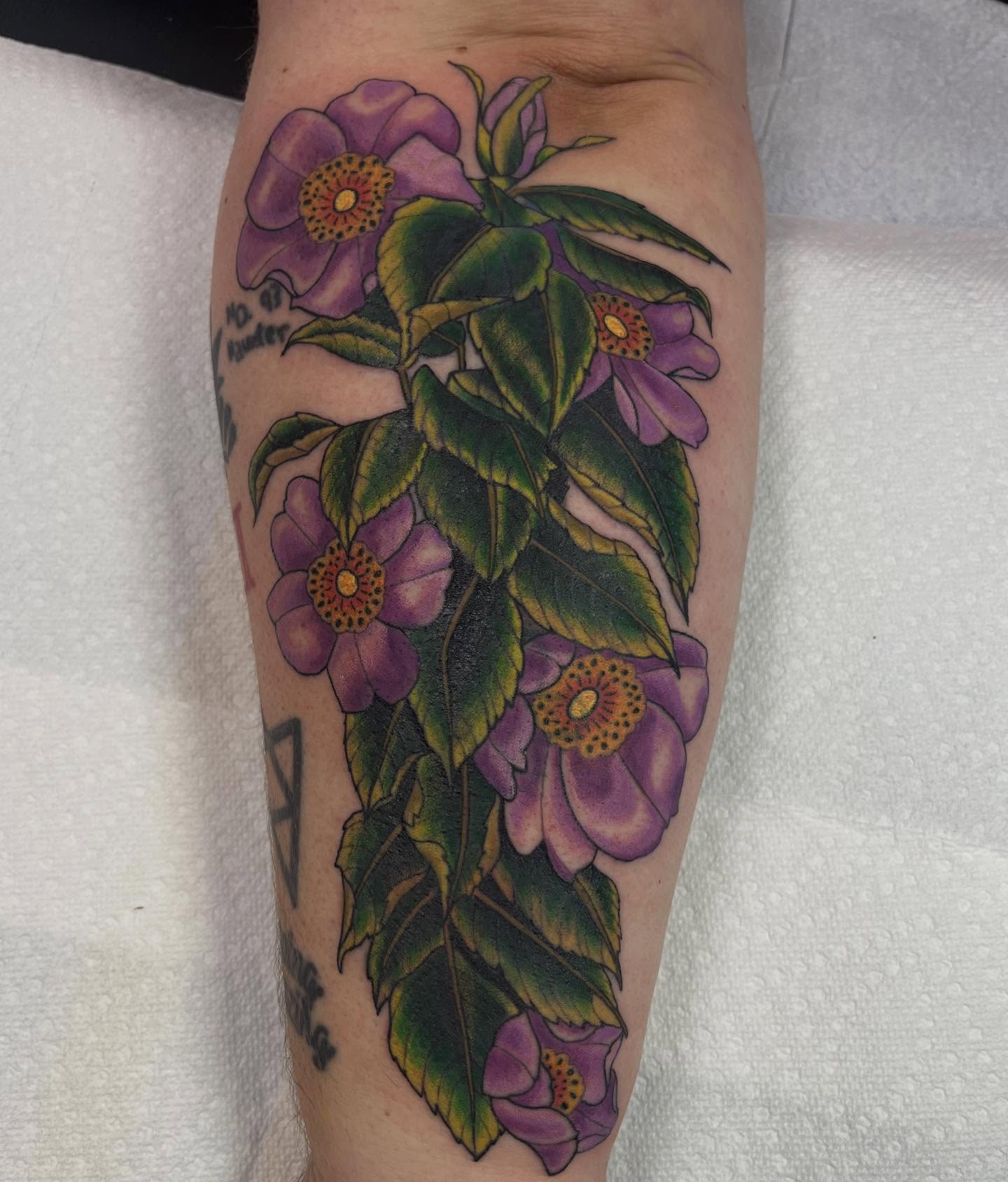 Purple flowers realism tattoo on the forearm by Brian Mcfadden
