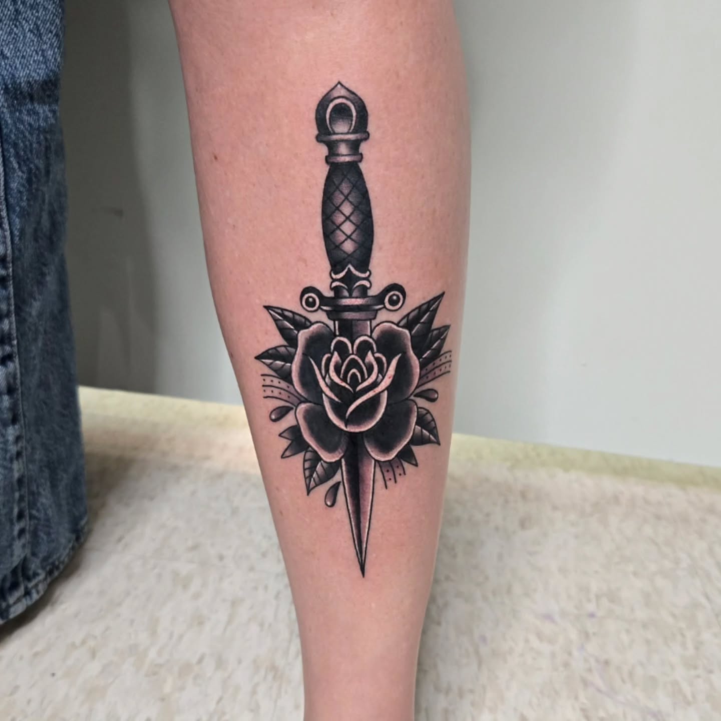 Knife and rose American traditional tattoo on the forearm by Jake Lee