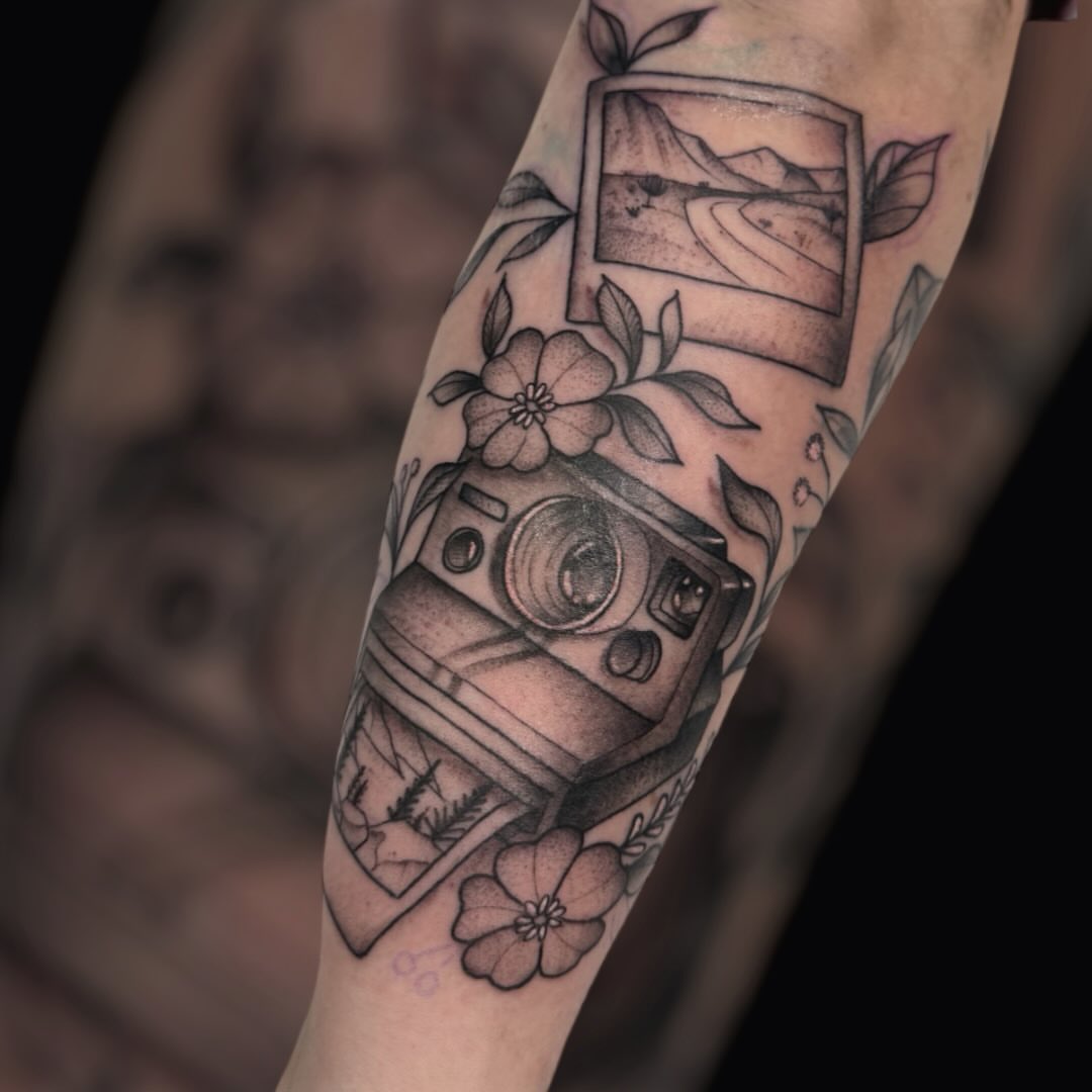 Camera and landscape realism tattoo on the forearm by Dameetra Davis
