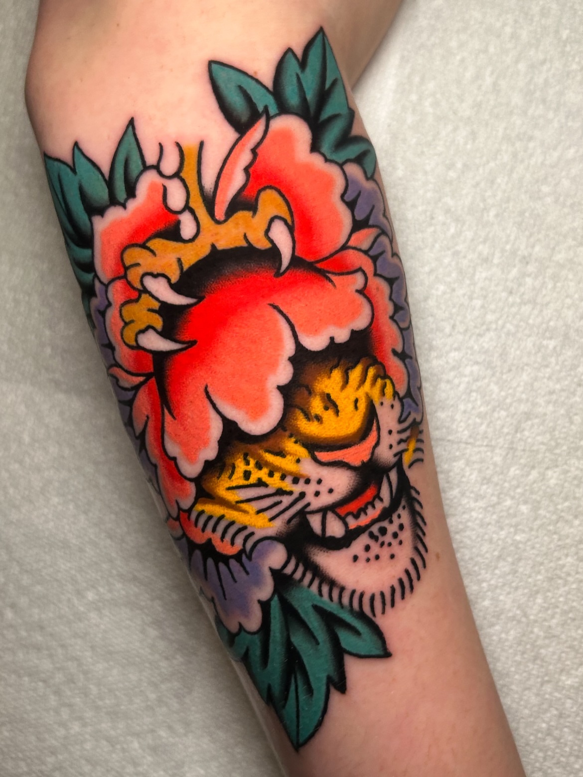 Tiger and flower American traditional tattoo on the forearm by Mitch Hoggard