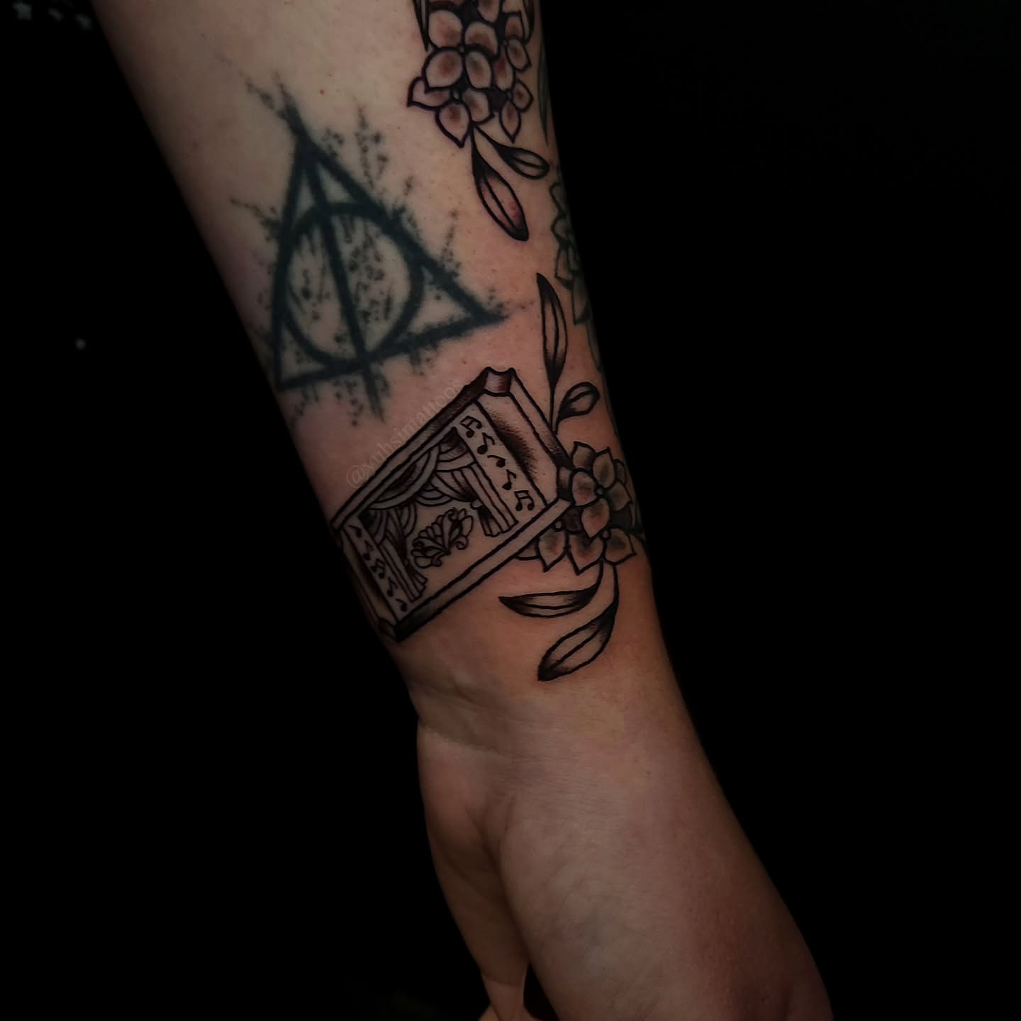 Book and flowers black and grey tattoo on the forearm by Sheena Yu-Hsin Wood
