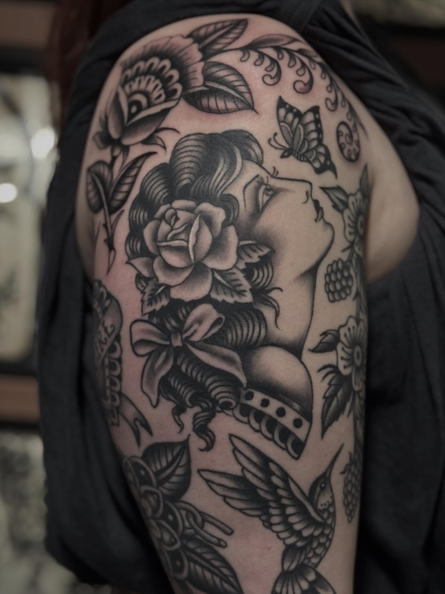 Woman with roses American traditional tattoo on the shoulder by Micah Norman, San Francisco, California