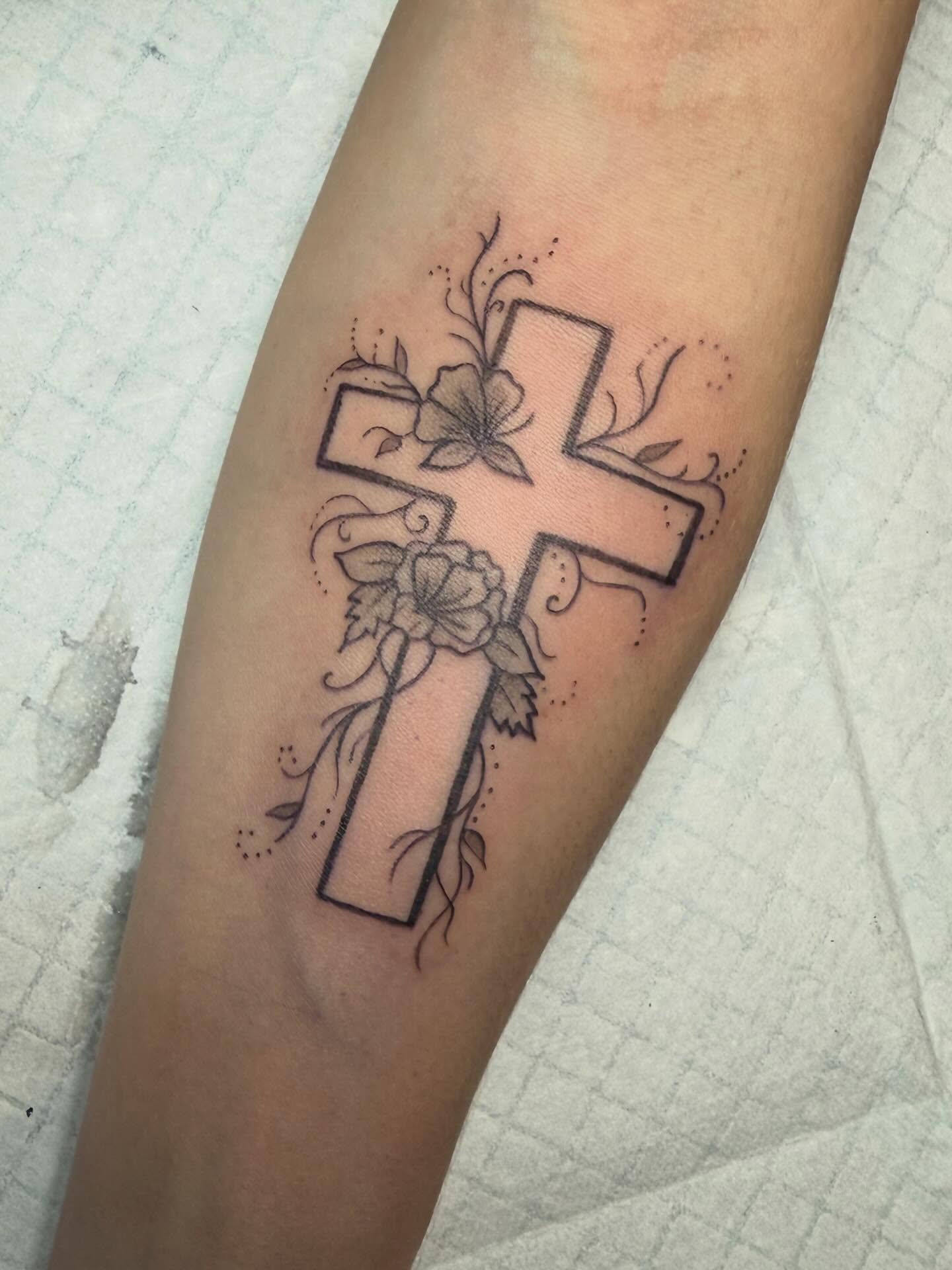 Cross with flowers black and grey tattoo on the forearm by zoie rozay hannah