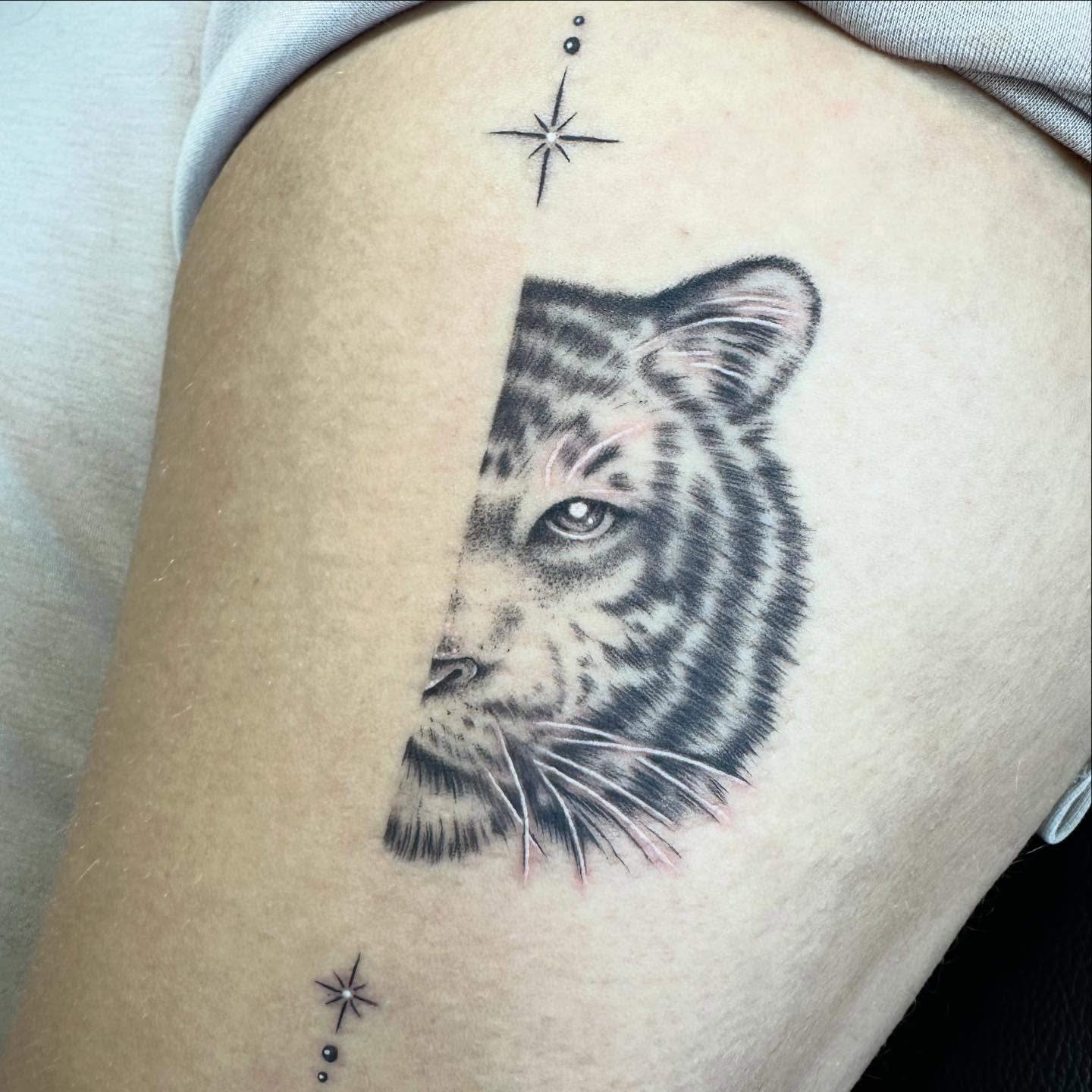Tiger dotwork tattoo on the thigh by Sarah Nash