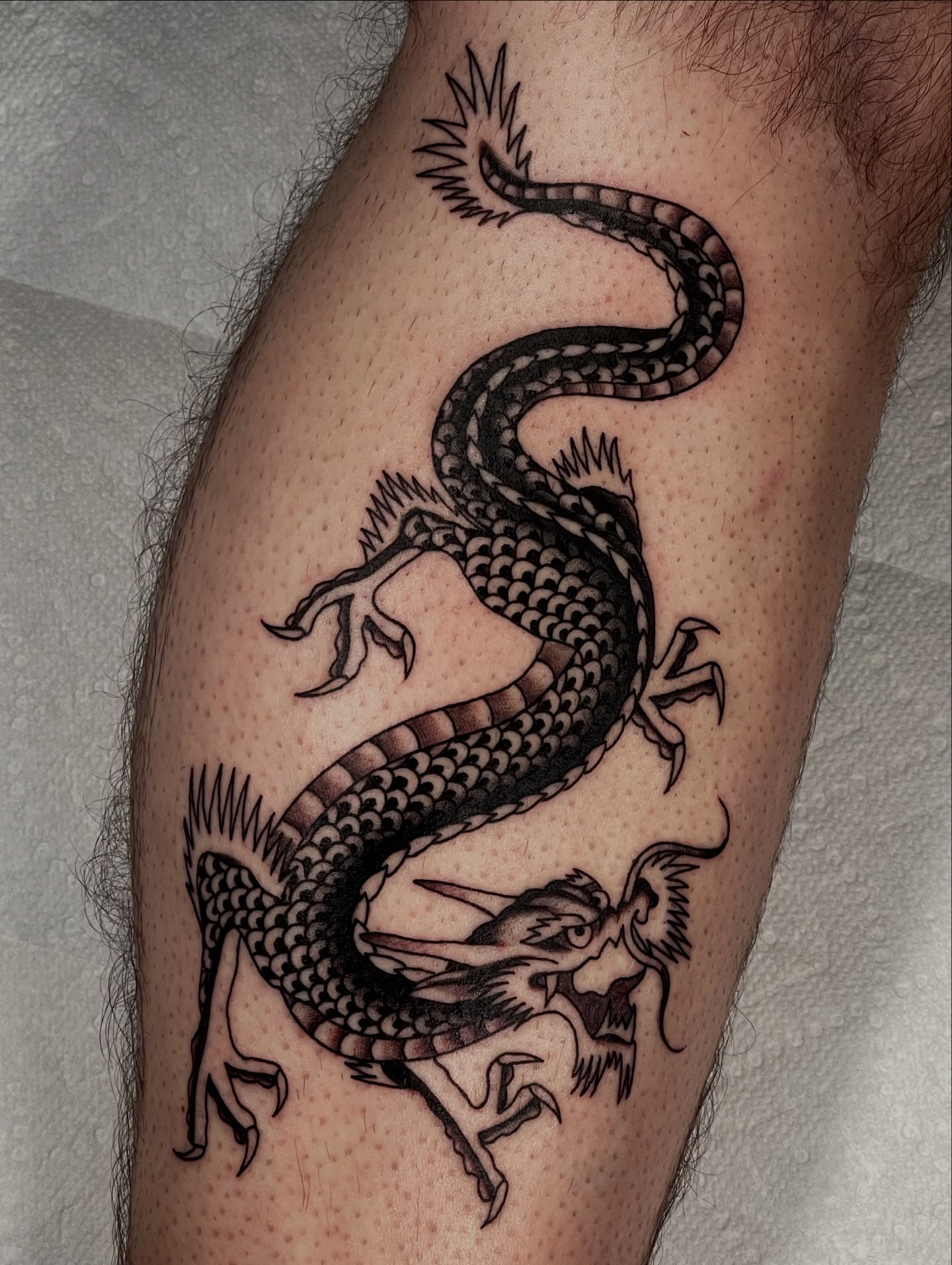 Dragon black and grey tattoo on the forearm by Chase Tucker
