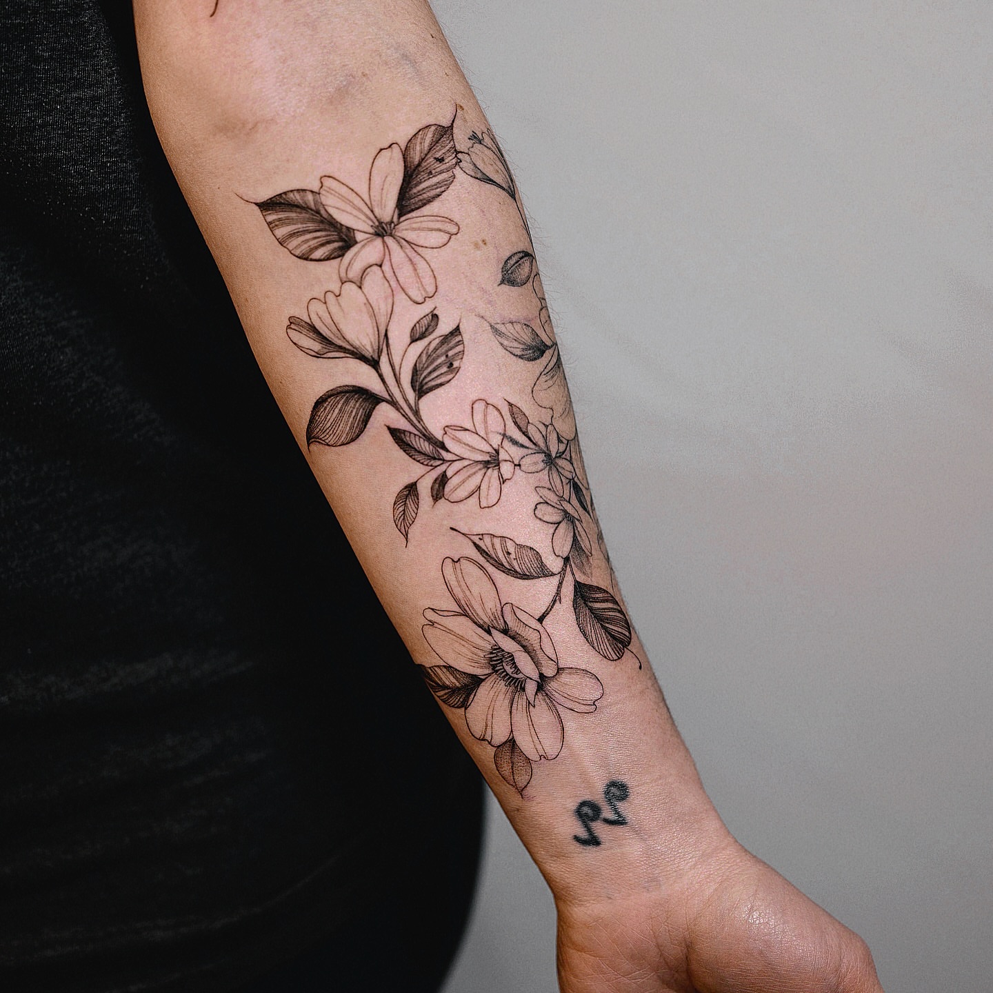 Floral bouquet black and grey tattoo on the forearm by Brad Simmons
