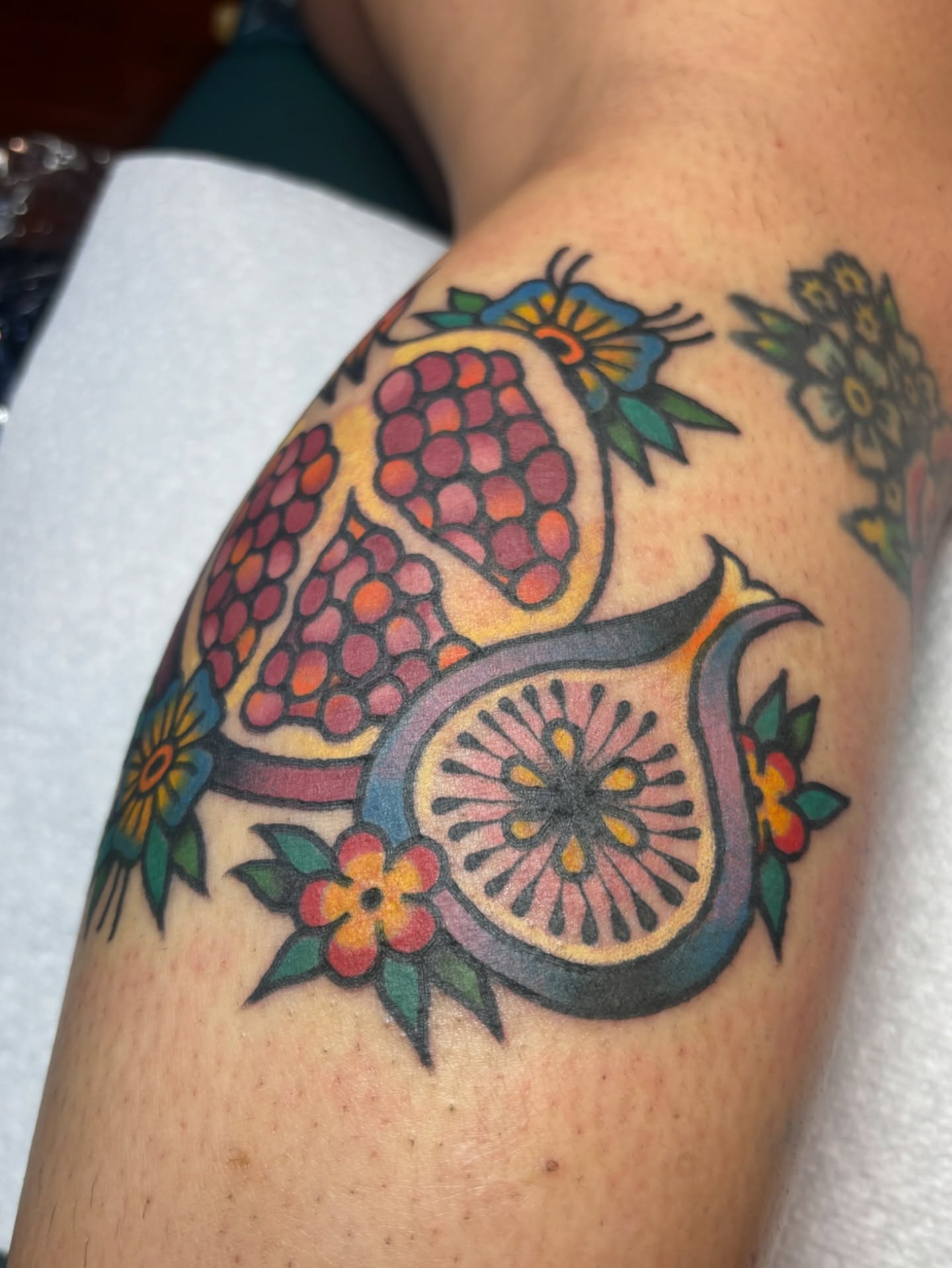 Pomegranate and orange slice American traditional tattoo on the shoulder by edith🌷, Murfreesboro, Tennessee