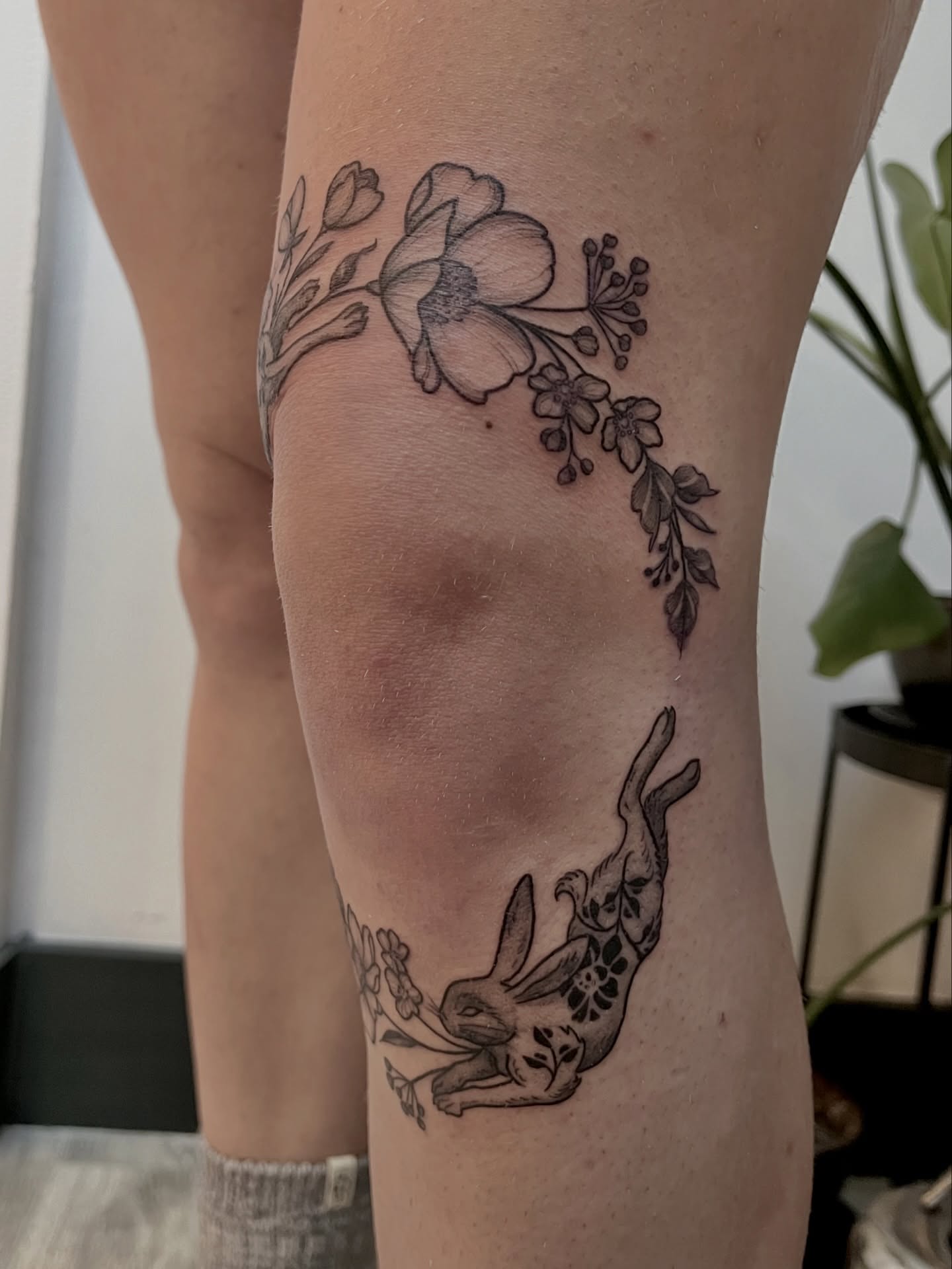 Flower and rabbit black and grey tattoo on the forearm by Lo Gwynn