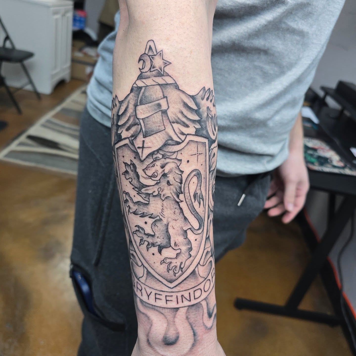 Gryffindor crest black and grey tattoo on the forearm by Jon Griffin, Maryville, Tennessee