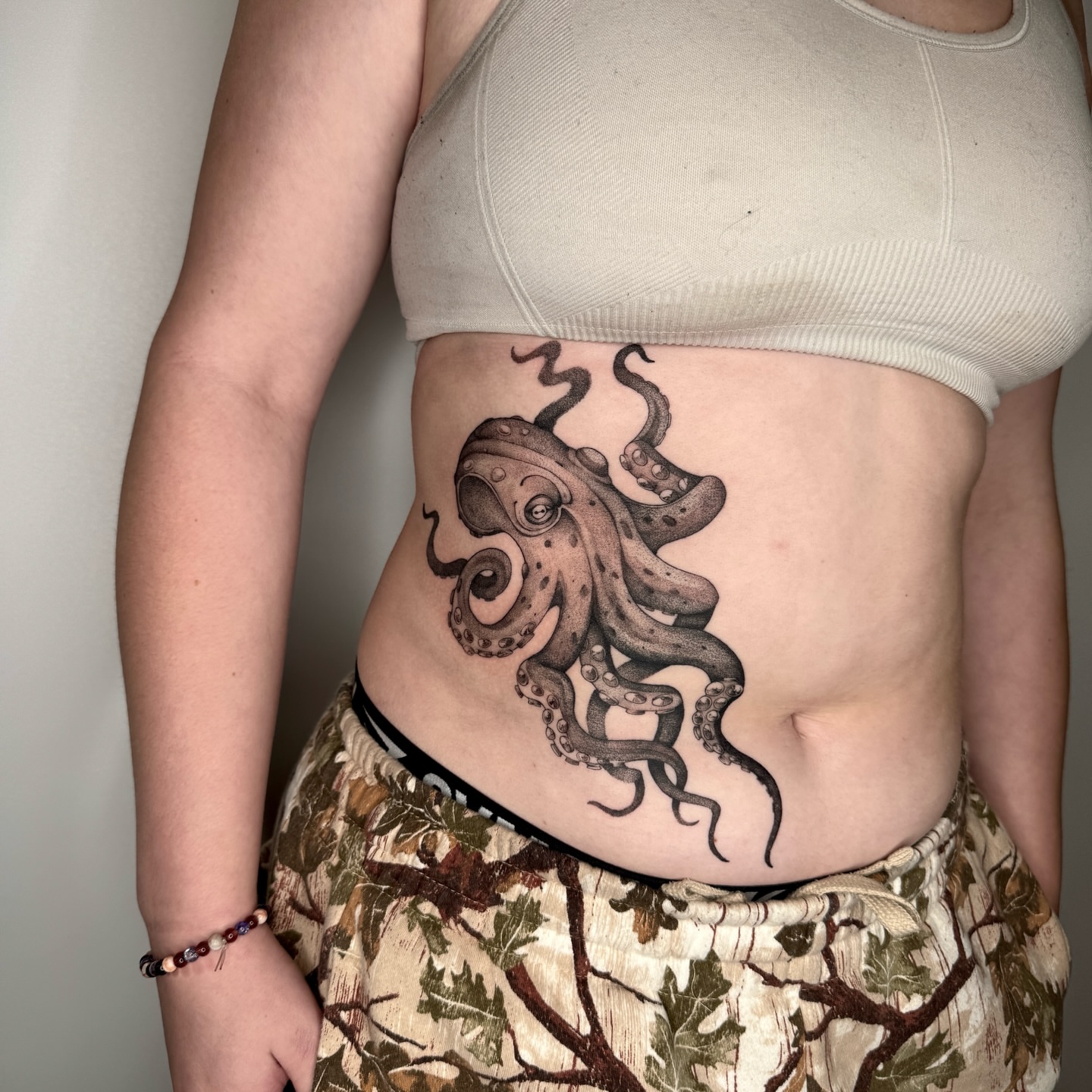 Octopus black and grey tattoo on the torso by Molly Murray
