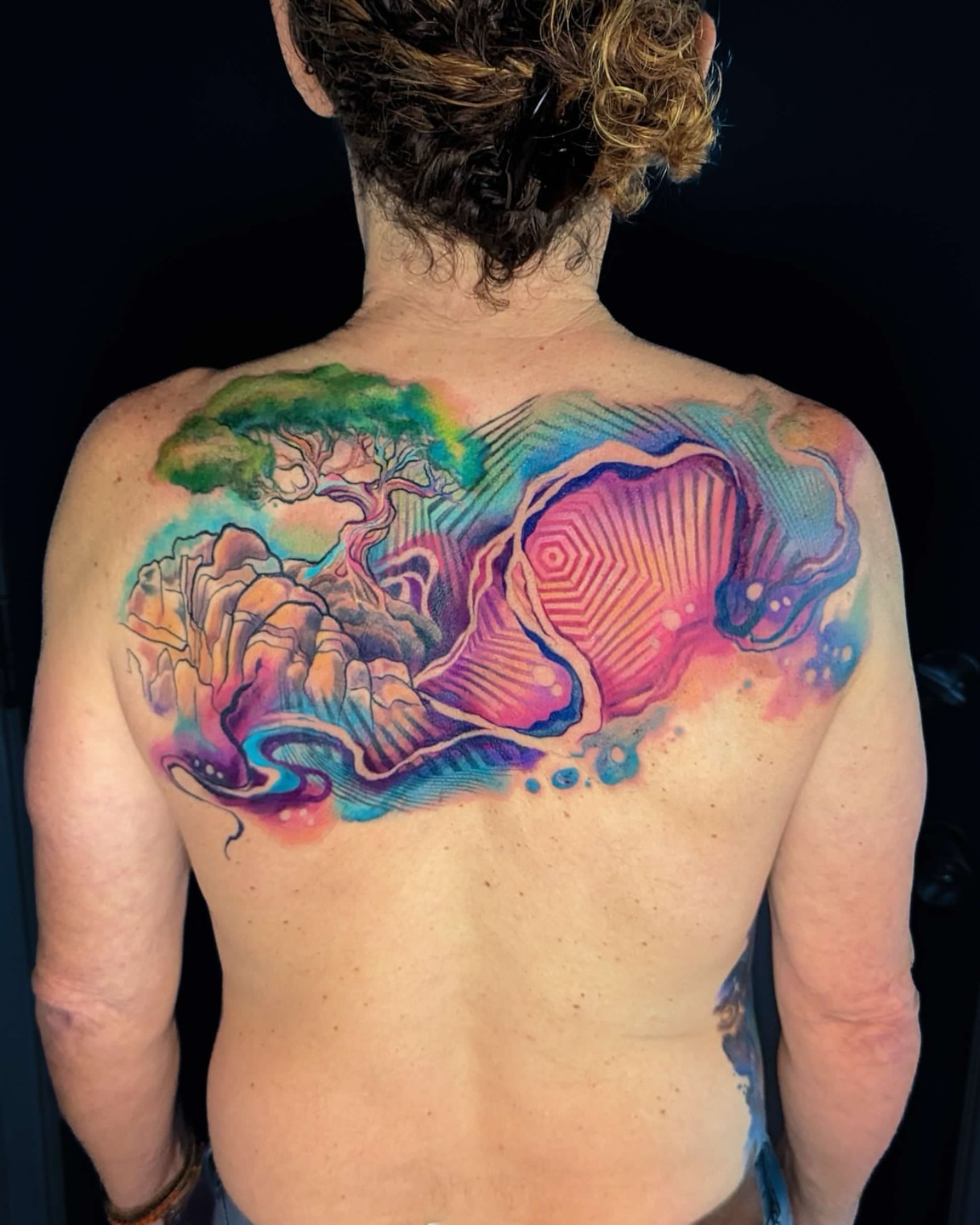 Abstract landscape watercolor tattoo on the back by Amy Zager
