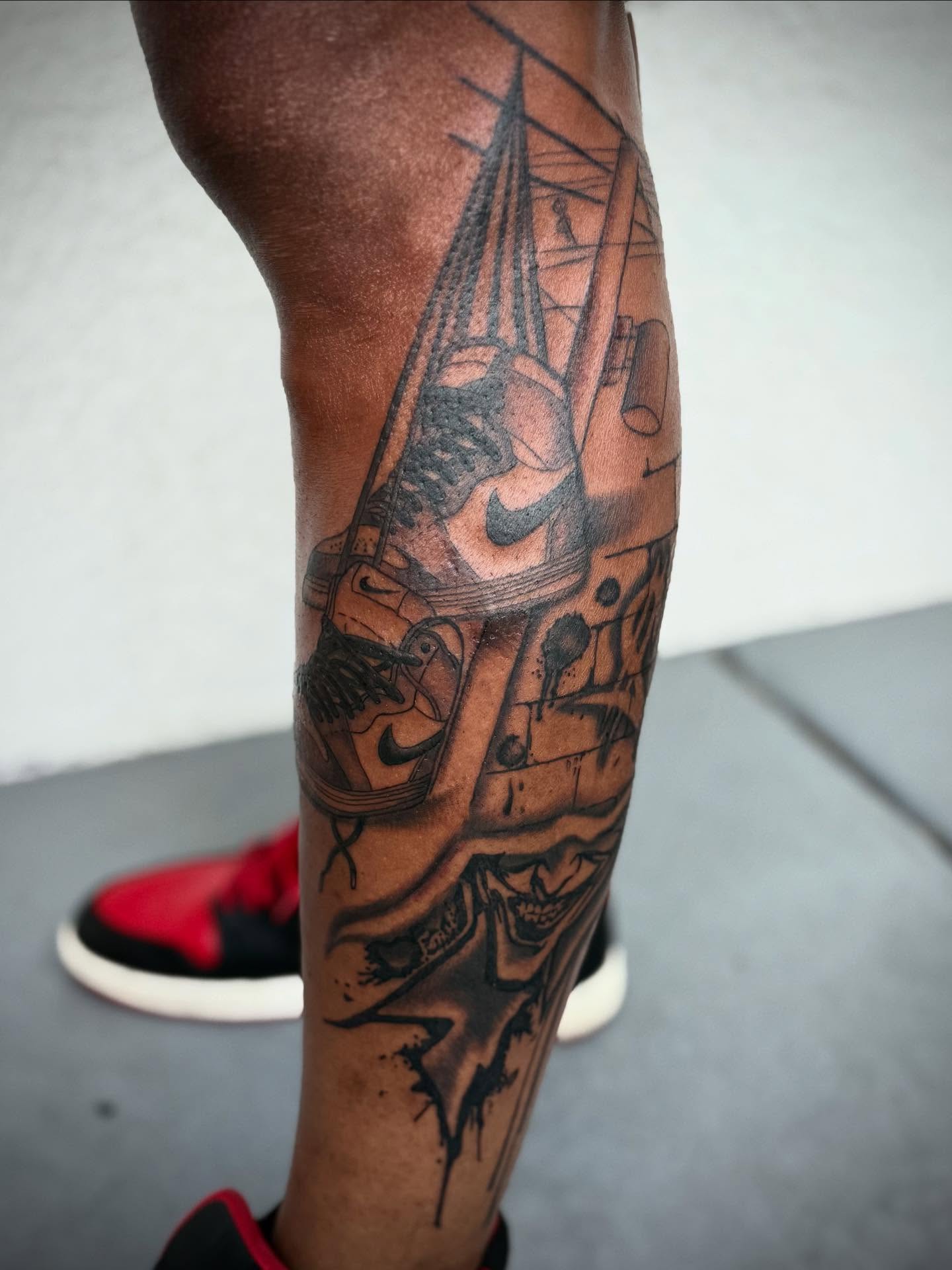 Ship and Nike swoosh black and grey tattoo on the forearm by abbie michelle