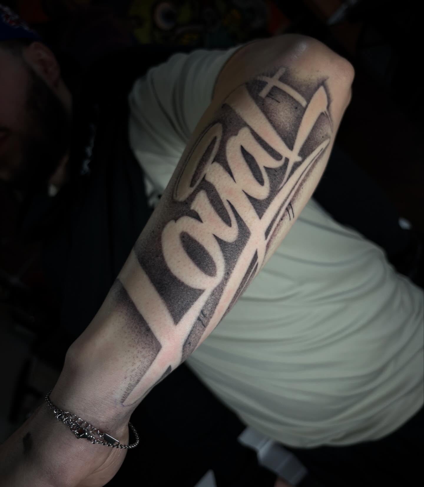 Loyalty lettering script tattoo on the forearm by Alexandria