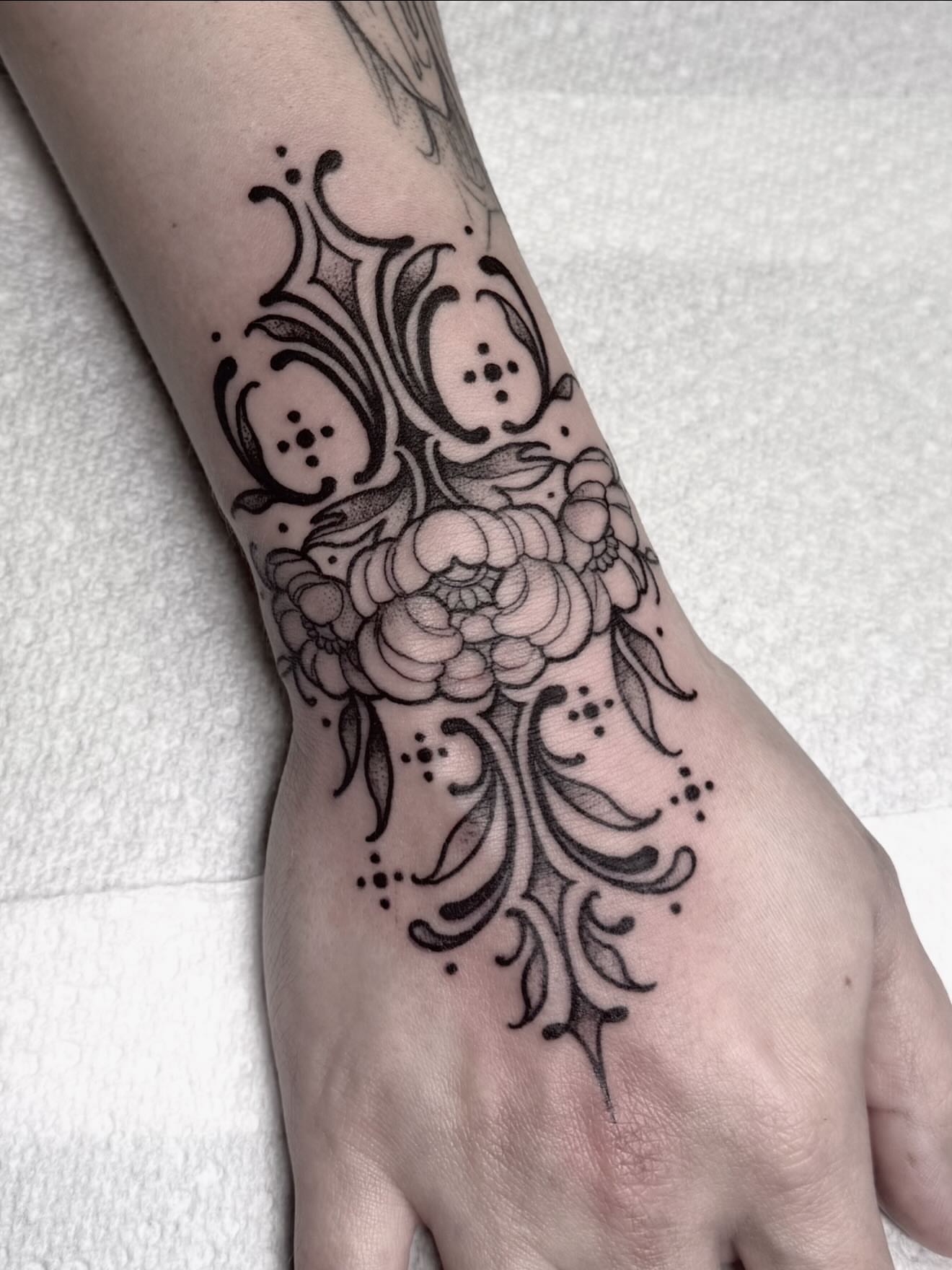 Floral design black and grey tattoo on the hand by Cincinnati