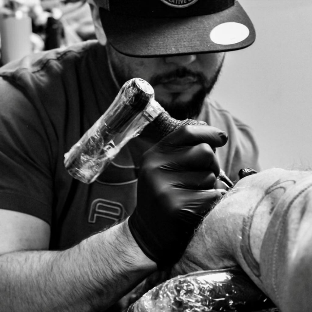 Floral design black and grey tattoo on the upper arm by Jorge Hernandez