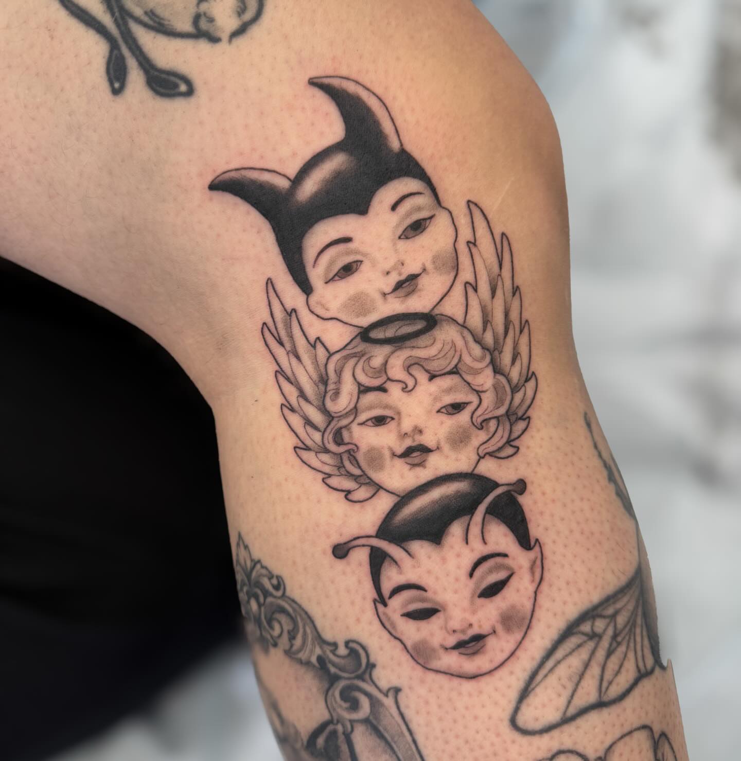 Angelic faces neo-traditional tattoo on the upper arm by Kaitlyn Brebner