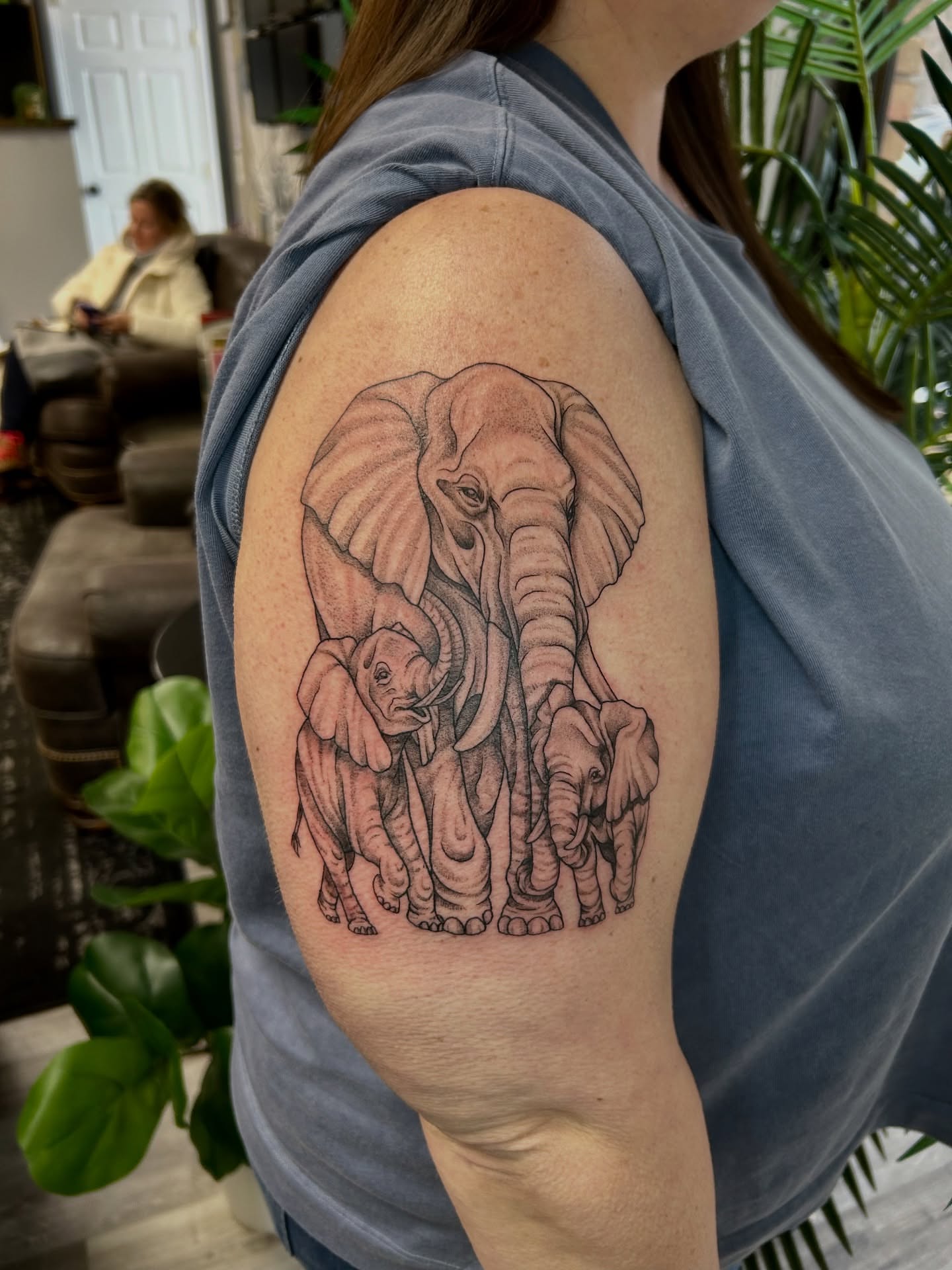 Elephant family realism tattoo on the upper arm by Taylor Heidtbrink