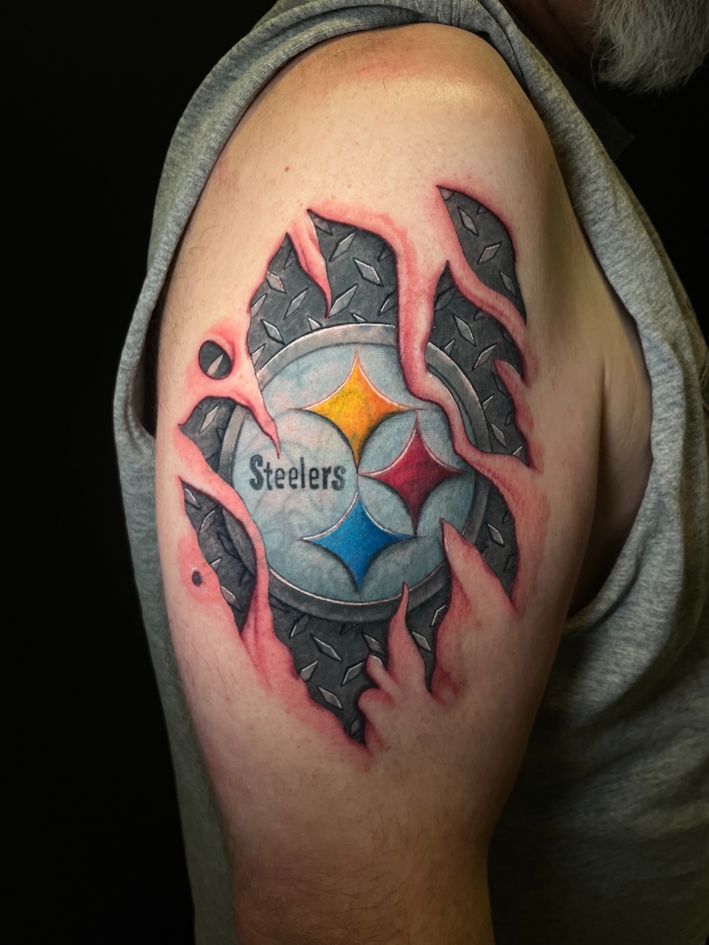 Steelers logo realism tattoo on the shoulder by Zachary Hayden