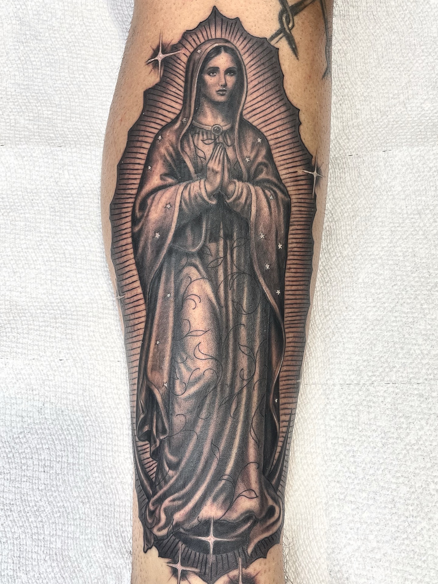 Virgin mary black and grey tattoo on the forearm by Alex Ortiz