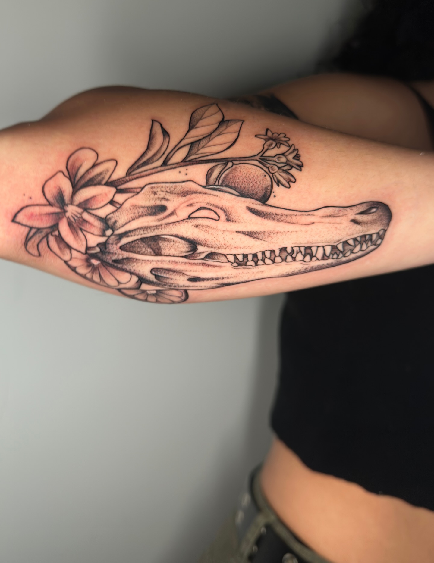Alligator skull with flowers realism tattoo on the forearm by zoe mars